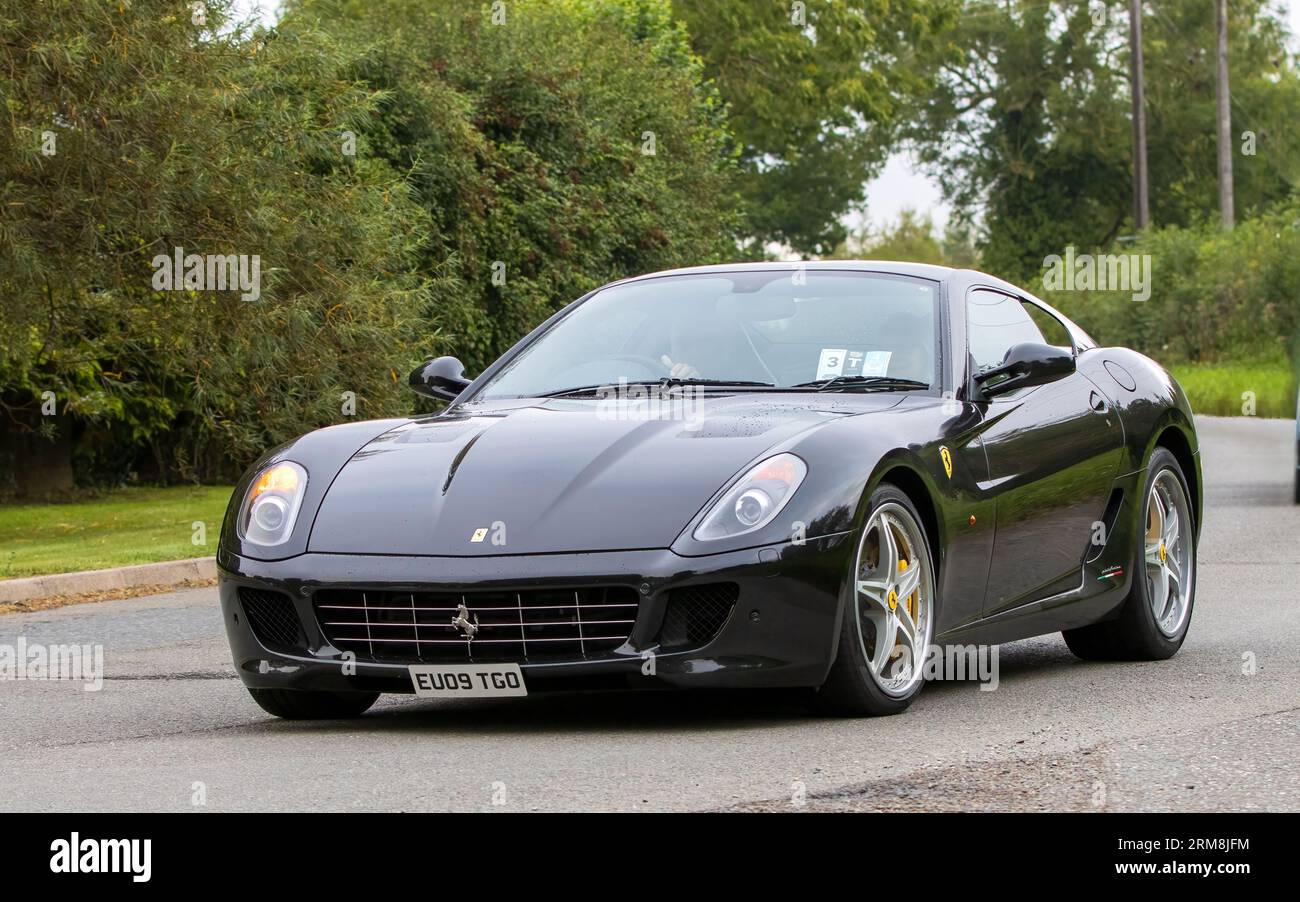Whittlebury, Northants, Regno Unito - 26 agosto 2023: 2009 auto nera Ferrari da 599 GTB Fiorano che viaggia su una strada di campagna inglese Foto Stock