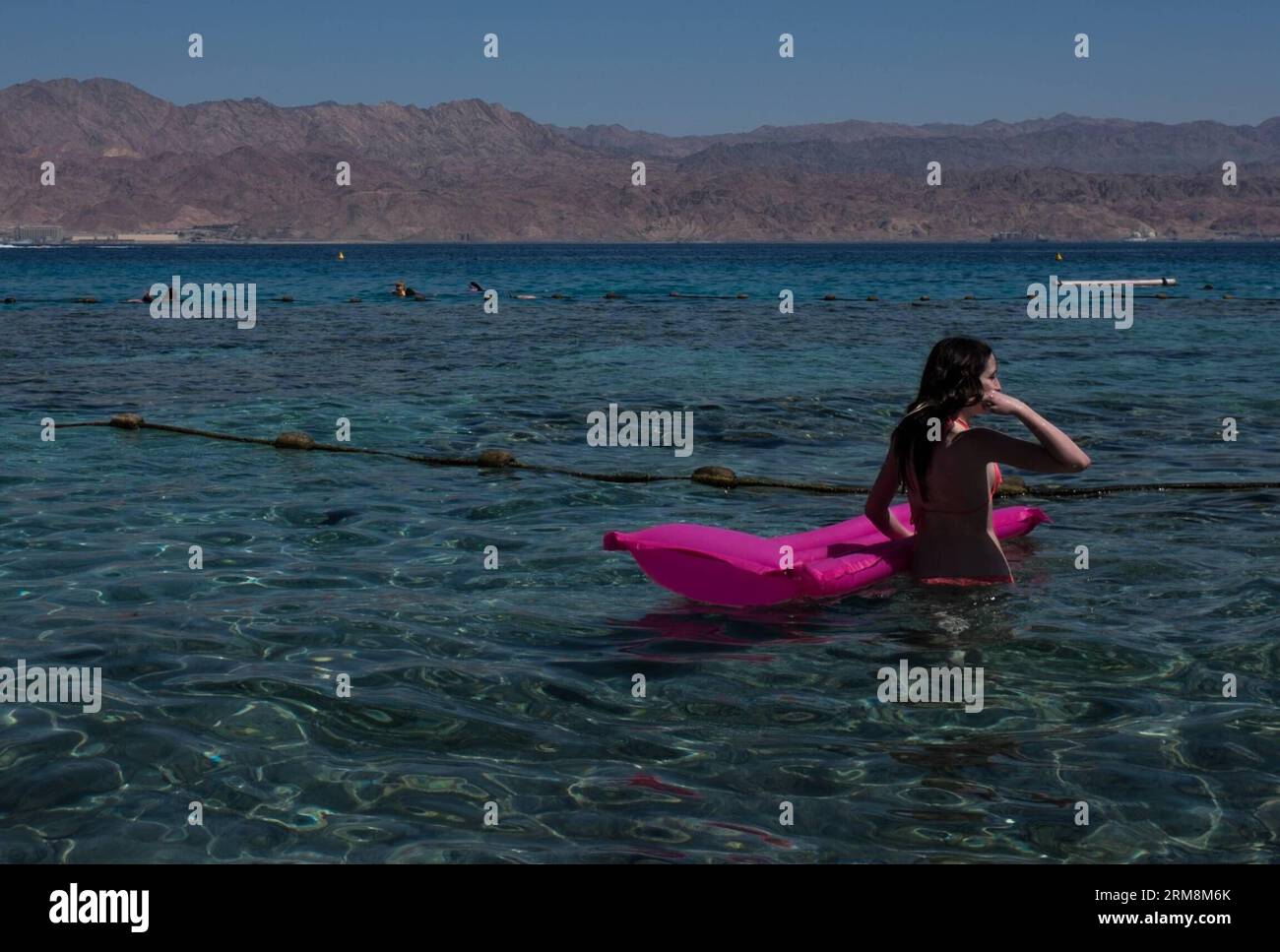 Una donna è stata vista nelle acque basse del Mar Rosso a Eilat, nel sud di Israele, il 18 aprile 2014. Molti visitatori sono venuti qui per svago durante la vacanza di Pasqua. Pesach è un importante festival ebraico biblicamente derivato celebrato dal 14 al 21 aprile di quest'anno. Il popolo ebraico celebra la Pasqua come una commemorazione della loro liberazione oltre 3.300 anni fa da Dio dalla schiavitù nell'antico Egitto governato dai faraoni, e la loro libertà come nazione sotto la guida di Mosè. Commemora la storia dell'Esodo come descritto nella Bibbia ebraica, specialmente nella B. Foto Stock