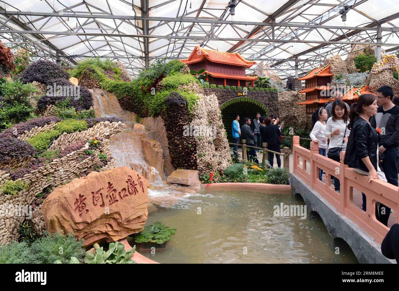 (140420) -- SHOUGUANG, 20 aprile 2014 (Xinhua) -- le persone camminano davanti a un paesaggio in miniatura fatto di verdure durante la 15a fiera internazionale della Cina (Shouguang) a Shouguang, nella provincia di Shandong della Cina orientale, 20 aprile 2014. La fiera annuale è iniziata a Shouguang, il più grande fornitore di verdure di Pechino, capitale della Cina, domenica. La fiera, che ha attirato espositori da oltre 20 paesi e regioni, durerà fino a maggio 30. (Xinhua/Zhu Zheng) (wjq) CHINA-SHANDONG-SHOUGUANG-VEGETERY FAIR (CN) PUBLICATIONxNOTxINxCHN Shouguang 20 aprile 2014 le celebrità di XINHUA camminano davanti a M Foto Stock