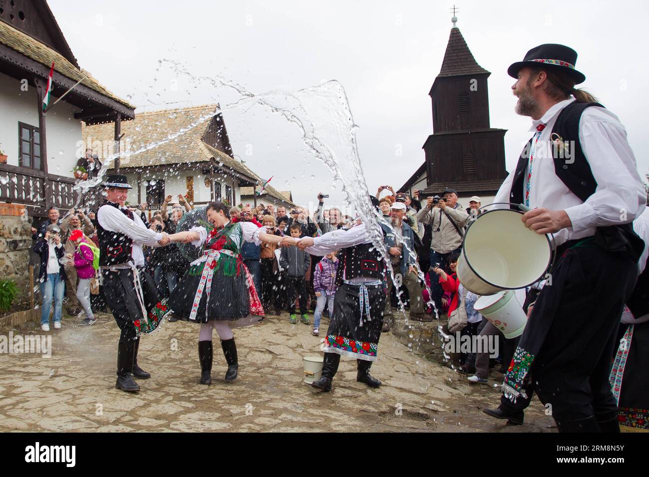 (140421) -- HOLLOKO, 21 aprile 2014 (Xinhua) -- uomini locali spruzzano acqua ad una ragazza come parte delle tradizionali celebrazioni pasquali a Holloko, un villaggio nel nord dell'Ungheria, 21 aprile 2014. La popolazione locale di Holloko, iscritta nella Lista del Patrimonio Mondiale dell'Umanità, celebra la Pasqua con il tradizionale innaffiamento delle ragazze , un rituale di fertilità tribale ungherese radicato nel passato pre-cristiano della zona. (Xinhua/Attila Volgyi)(zhf) UNGHERIA-HOLLOKO-LUNEDÌ DI PASQUA-CELEBRAZIONI PUBLICATIONxNOTxINxCHN 21 aprile 2014 XINHUA Local Men Splash Water AT a Girl come parte delle tradizionali celebrazioni pasquali in a Vill Foto Stock