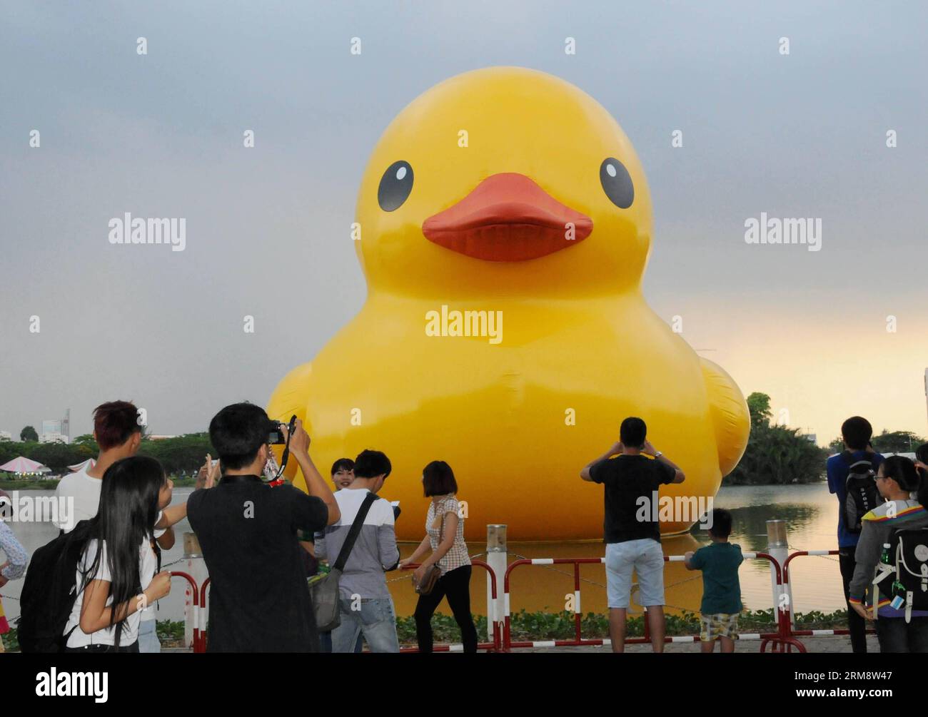 (140427) -- HO CHI MINH CITY, aprile 26 (Xinhua) -- le persone scattano foto della gigantesca anatra di gomma nella zona residenziale di Phu My Hung a ho chi Minh City, Vietnam, 26 aprile 2014. Un'anatra di gomma alta 18 metri, che ha affascinato persone in tutto il mondo, sarà esposta presso il lago Crescent nella zona residenziale di Phu My Hung della città di HCM da aprile 27 a maggio 31, secondo quanto riportato dai media locali sabato. Disegnata dall'artista olandese Florentijn Hofman, l'anatra di gomma ha iniziato un tour intitolato "Spanding Joys Around the World" nel 2007. HCM City sarà la sedicesima sede in cui verrà esposta. (Xinhua/Tao Jun) (dzl) Foto Stock