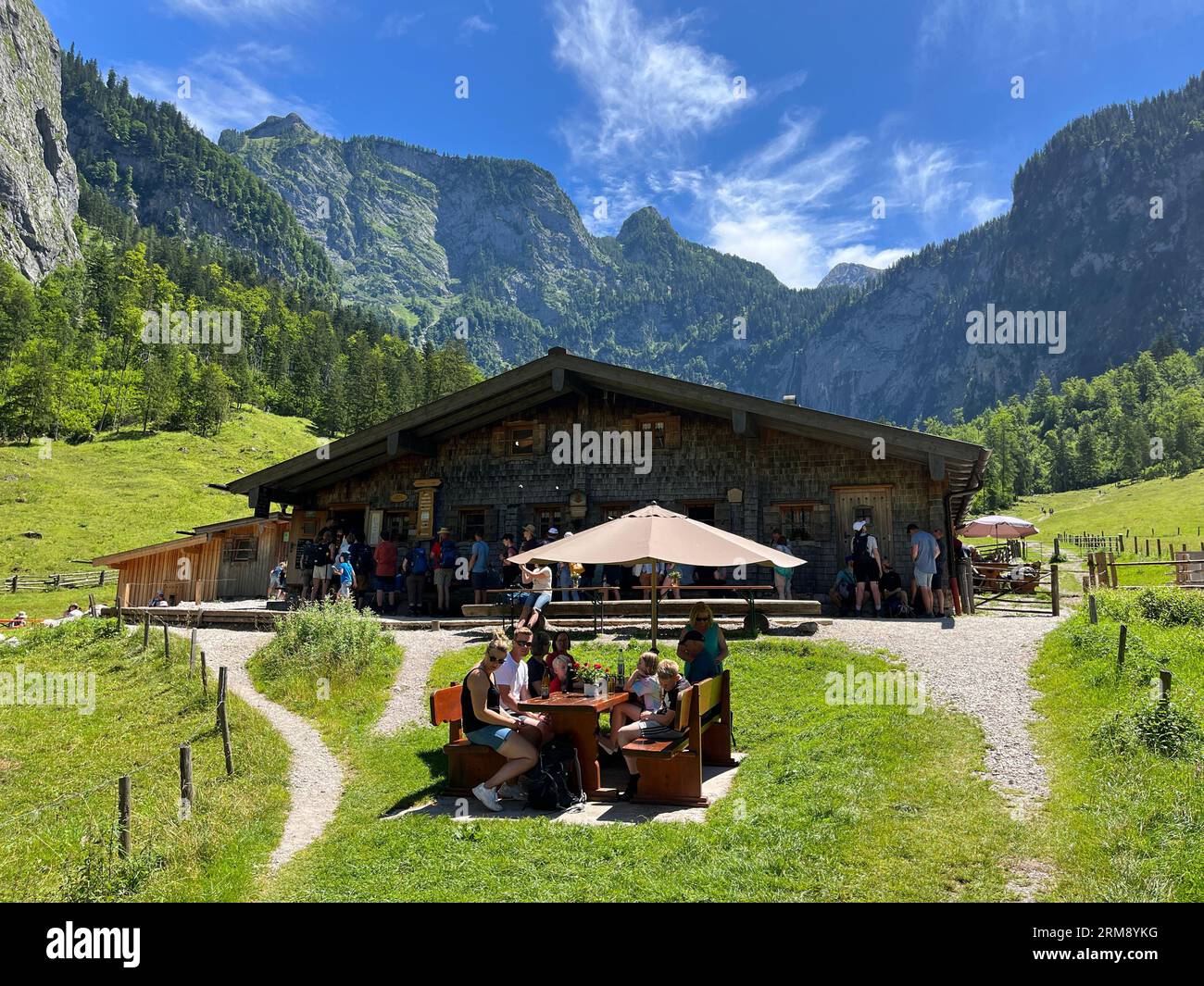 Schönau am Königssee, Germania - 14 luglio 2022: I turisti che si godono un pasto e al rifugio Fischunkelalm sull'Obersee nel Parco Nazionale Berchtesgaden Foto Stock
