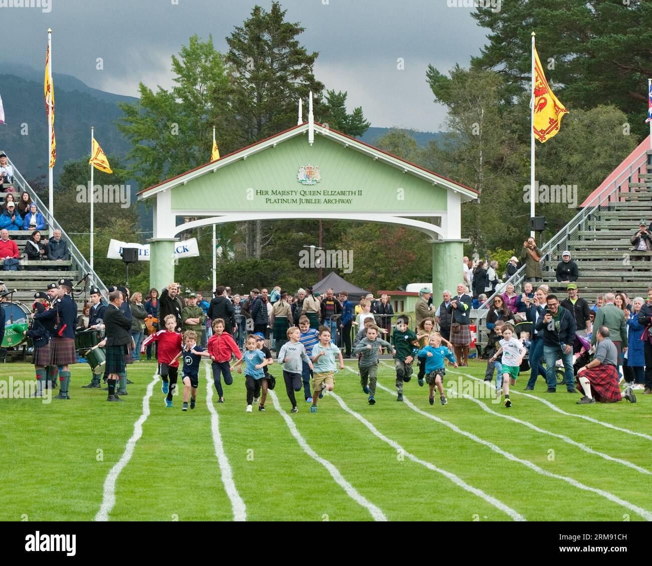 Giovani ragazzi che corrono a Braemar Gathering, Highland Games, Aberdeenshire. Foto Stock