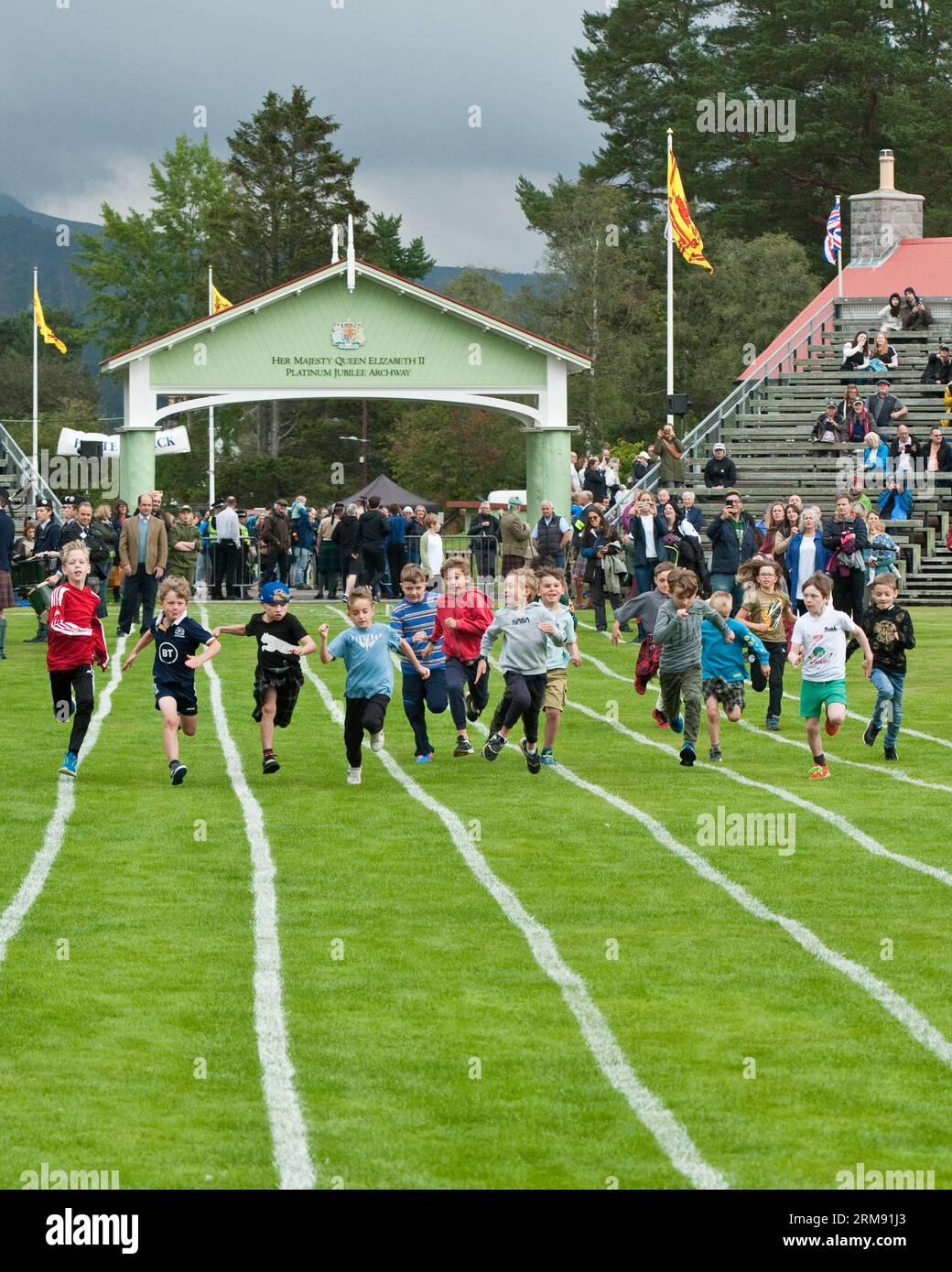 Giovani ragazzi che corrono a Braemar Gathering, Highland Games, Aberdeenshire. Foto Stock