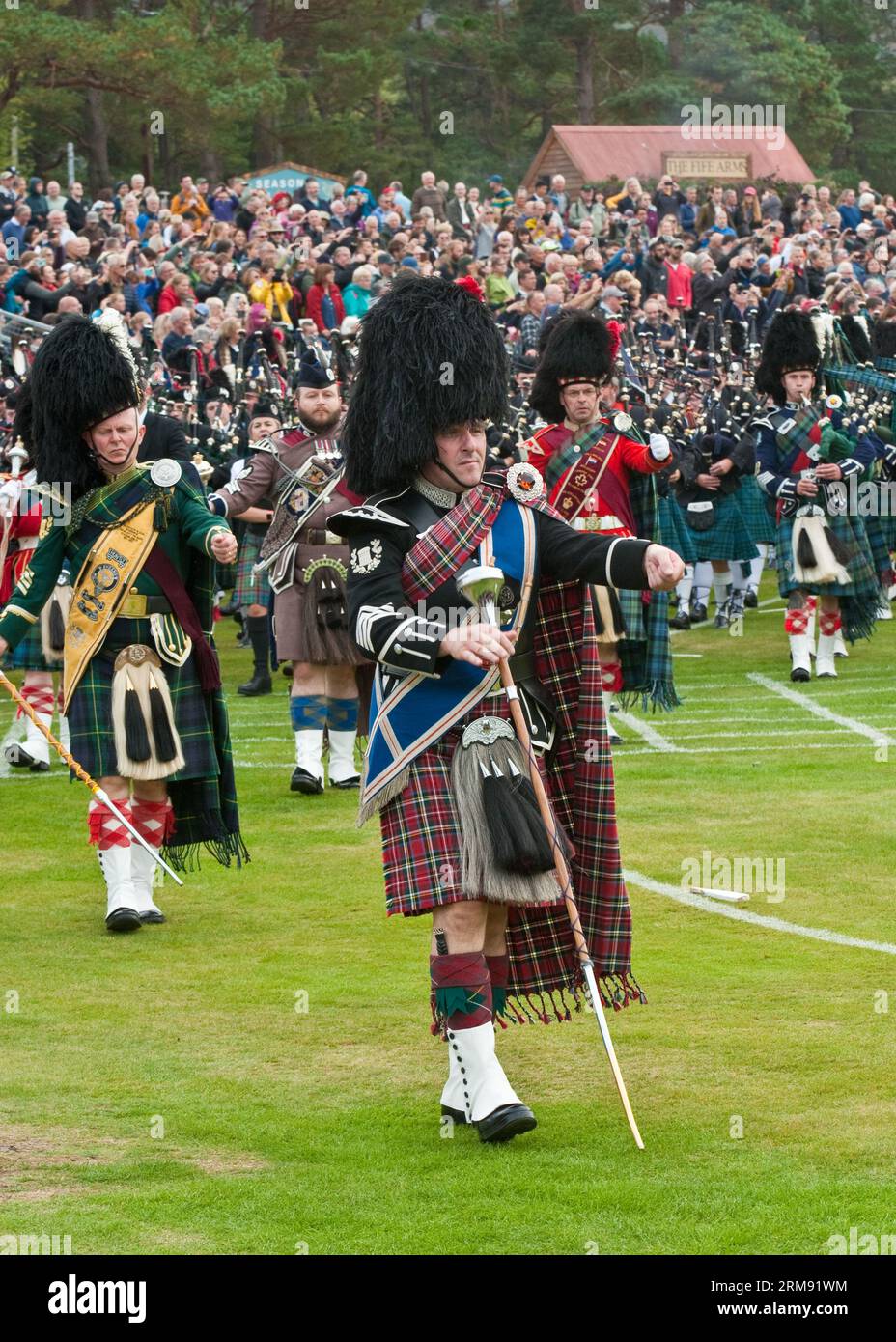 Band scozzesi Massed Pipe che marciano e suonano al "Braemar Gathering", Highland Games, Scozia. Foto Stock