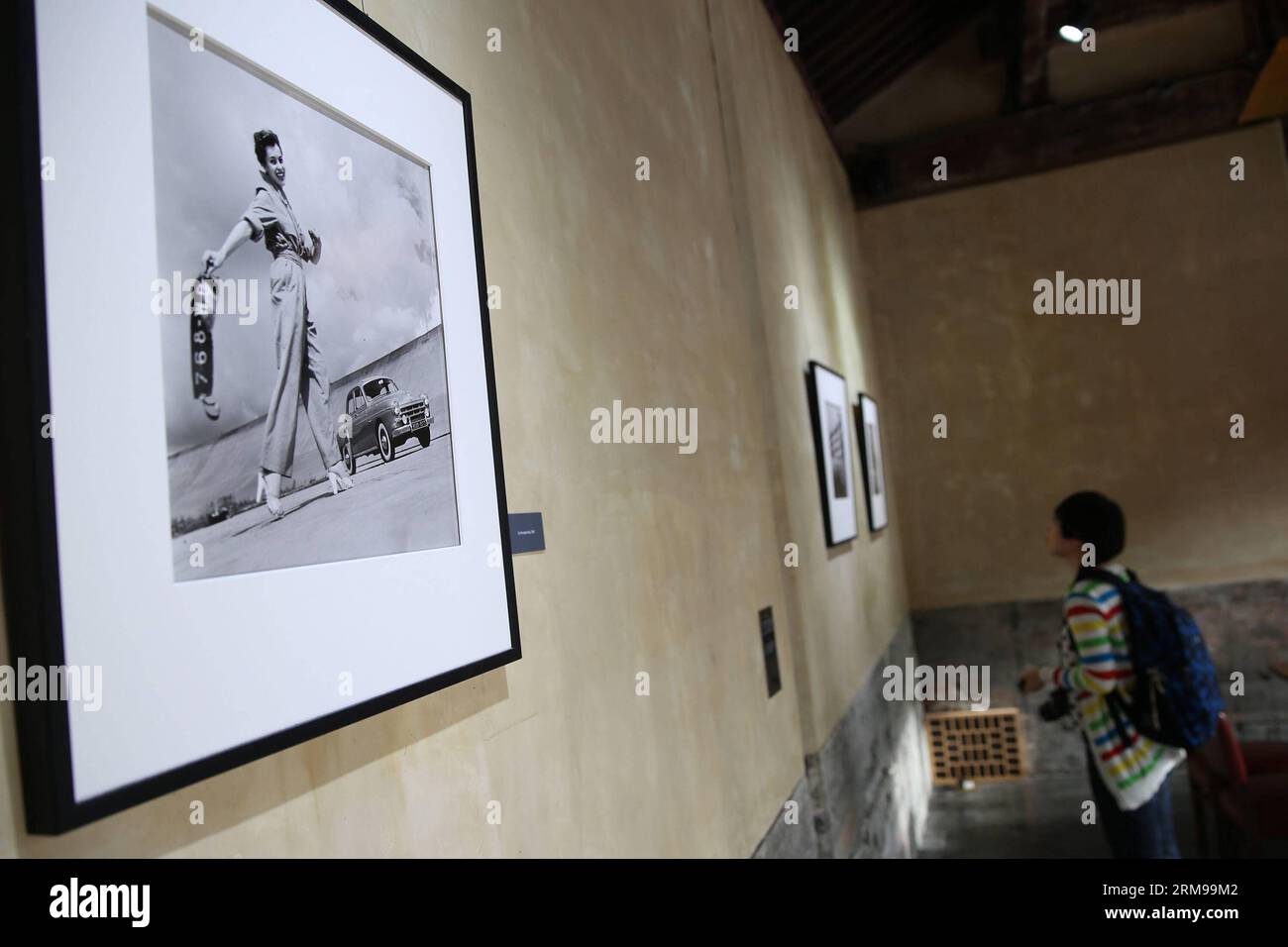 (140514) -- PECHINO, 14 maggio 2014 (Xinhua) -- Un visitatore guarda le foto del fotografo francese Robert Doisneau in una mostra fotografica a Pechino, capitale della Cina, 14 maggio 2014. Mercoledì è iniziata una mostra intitolata Doisneau S Renault. Più di 70 foto di Doisneau, uno dei più grandi fotografi del XX secolo, sono esposte nella mostra che durerà fino a giugno 30. (Xinhua/Wang Shen)(wjq) CHINA-BEIJING-DOISNEAU S RENAULT-PHOTO EXHIBITION (CN) PUBLICATIONxNOTxINxCHN Pechino 14 maggio 2014 XINHUA a Visitor Looks AT Pictures by French Photo Robert AT a Photo Exhibiti Foto Stock