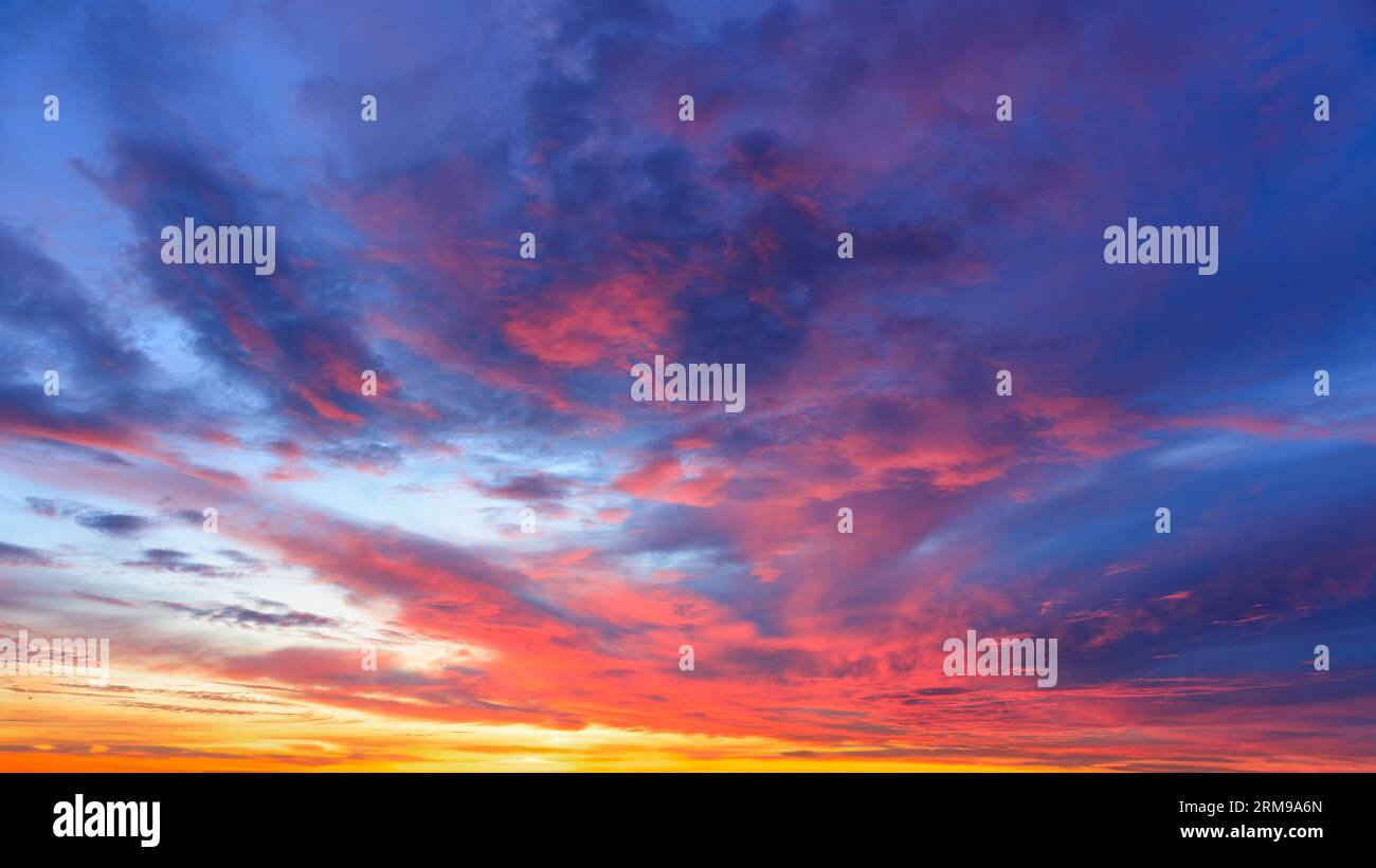 Spara il cielo all'alba. Vivaci toni blu, rosso e giallo. Il sole è nascosto. Foto Stock