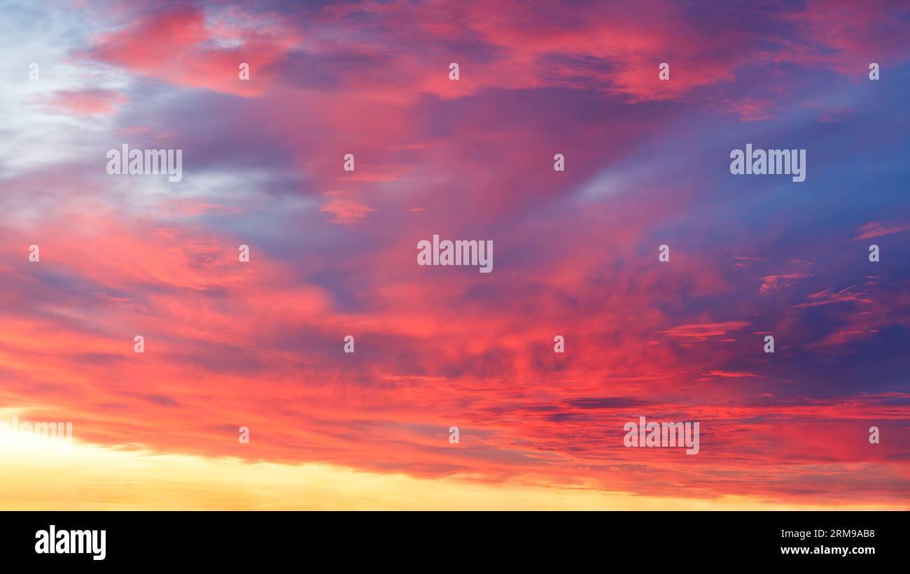 Spara il cielo all'alba. Vivaci toni blu, rosso e giallo. Foto Stock