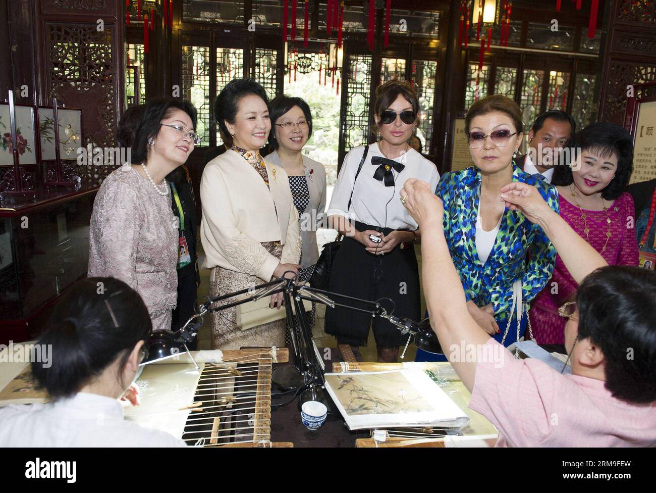 (140521) -- SHANGHAI, 21 maggio 2014 (Xinhua) -- Peng Liyuan (2nd L), moglie del presidente cinese Xi Jinping, insieme ai coniugi di leader mondiali che partecipano al quarto vertice della Conferenza sulle misure di interazione e rafforzamento della fiducia in Asia (CICA), guarda su Huiping, un successore del patrimonio culturale non materiale cinese GU Embroidery, dimostrando il mestiere di GU Embroidery, a Shanghai, 21 maggio 2014. (Xinhua/Huang Jingwen) (yxb) CHINA-SHANGHAI-CICA-SUMMIT-PENG LIYUAN-SPOSES (CN) PUBLICATIONxNOTxINxCHN Shanghai 21 maggio 2014 XINHUA Peng Liyuan 2nd l moglie del presidente cinese Xi Jinpin Foto Stock