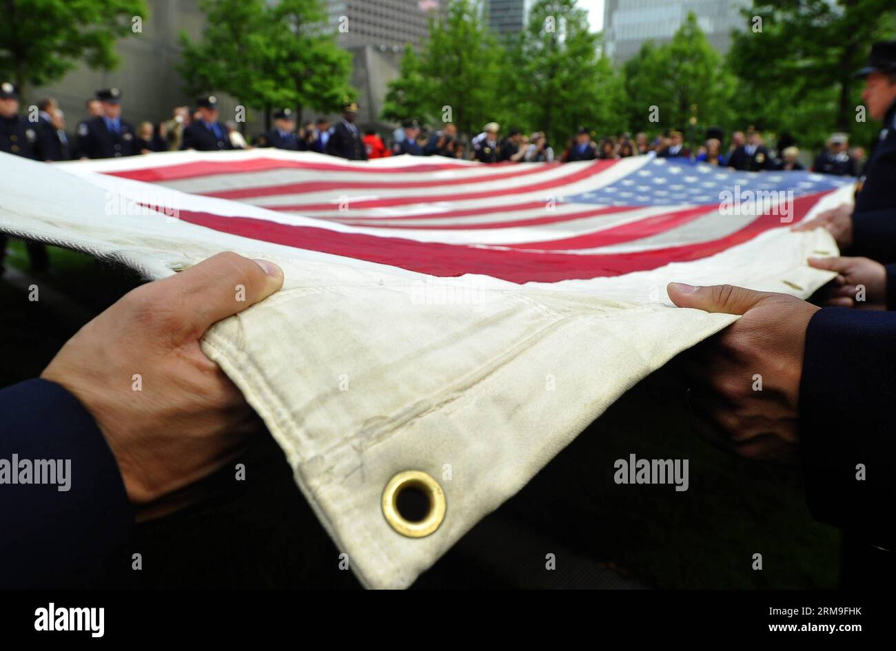 (140521) -- NEW YORK, 21 maggio 2014 (Xinhua) -- la gente tiene la bandiera nazionale 9/11 davanti al National September 11 Memorial Museum di New York, Stati Uniti, 21 maggio 2014. Il museo commemorativo di mercoledì è stato aperto al pubblico dopo un trasferimento cerimoniale della National 9/11 Flag, una bandiera americana che aveva volato al 90 di West Street, adiacente a Ground Zero, per settimane dopo gli attacchi, nella collezione permanente del museo. (Xinhua/Wang lei) US-NEW YORK-SEPT. 11 MEMORIAL MUSEUM - APERTURA AL PUBBLICO PUBLICATIONxNOTxINxCHN New York 21 maggio 2014 le celebrità di XINHUA tengono il National Foto Stock