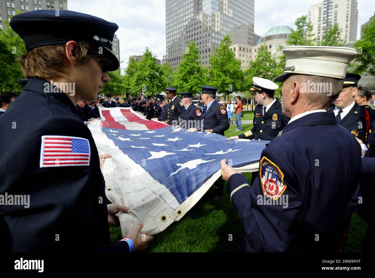(140521) -- NEW YORK, 21 maggio 2014 (Xinhua) -- i vigili del fuoco, la polizia e i membri dell'esercito tengono la National 9/11 Flag davanti al National September 11 Memorial Museum di New York, Stati Uniti, 21 maggio 2014. Il museo commemorativo di mercoledì è stato aperto al pubblico dopo un trasferimento cerimoniale della National 9/11 Flag, una bandiera americana che aveva volato al 90 di West Street, adiacente a Ground Zero, per settimane dopo gli attacchi, nella collezione permanente del museo. (Xinhua/Wang lei) US-NEW YORK-SEPT. 11 MEMORIAL MUSEUM - APERTURA AL PUBBLICO PUBLICATIONxNOTxINxCHN New York 21 maggio Foto Stock