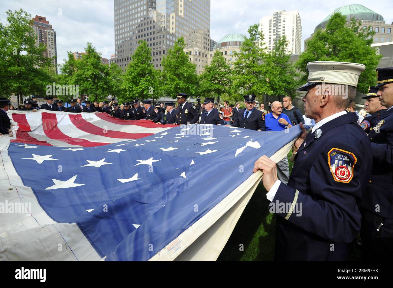 (140521) -- NEW YORK, 21 maggio 2014 (Xinhua) -- i vigili del fuoco, la polizia e i membri dell'esercito tengono la National 9/11 Flag davanti al National September 11 Memorial Museum di New York, Stati Uniti, 21 maggio 2014. Il museo commemorativo di mercoledì è stato aperto al pubblico dopo un trasferimento cerimoniale della National 9/11 Flag, una bandiera americana che aveva volato al 90 di West Street, adiacente a Ground Zero, per settimane dopo gli attacchi, nella collezione permanente del museo. (Xinhua/Wang lei) US-NEW YORK-SEPT. 11 MEMORIAL MUSEUM - APERTURA AL PUBBLICO PUBLICATIONxNOTxINxCHN New York 21 maggio Foto Stock
