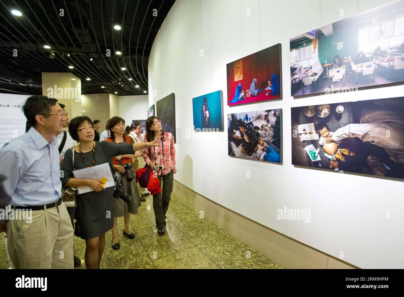Huang Wen (2nd L), presidente della giuria del 10th China International Press Photo Contest (CHIPP), presenta le foto ai visitatori della 10th CHIPP Winning Photos Exhibition a Pechino, capitale della Cina, il 24 maggio 2014. La mostra, con 229 foto vincitrici, ha avuto inizio sabato al China Millennium Monument. (Xinhua/Zhao Bing) (zwy) CHINA-BEIJING-CHIPP-PHOTO EXHIBITION(CN) PUBLICATIONxNOTxINxCHN Huang Wen 2nd l Presidente della giuria del 10° China International Press Photo Contest CHIPP presenta le foto ai visitatori ALLA 10° CHIPP Winning Photos Exhibition di Pechino, CA Foto Stock