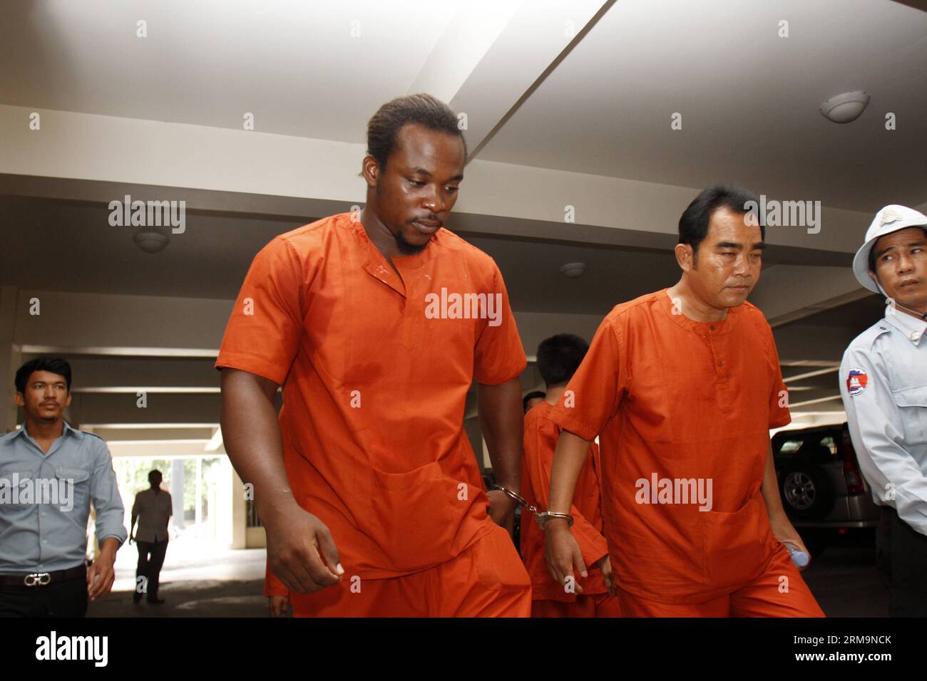 (140528) -- PHNOM PENH, 28 maggio 2014 (Xinhua) -- il prezioso Chneme Nwoko nazionale nigeriano (1st L, fronte) viene portato al tribunale municipale di Phnom Penh per ascoltare il suo verdetto a Phnom Penh, Cambogia, 28 maggio 2014. Il tribunale municipale di Phnom Penh mercoledì ha condannato tre stranieri, tra cui un nigeriano, un adolescente francese e una donna australiana di traffico di droga, condannandoli a un periodo compreso tra 23 e 27 anni di carcere, secondo un verdetto letto dal giudice Kor Vandy. (Xinhua/Sovannara)(zjl) CAMBOGIA-PHNOM PENH-STRANIERI-PRIGIONE-TRAFFICO DI EROINA PUBLICATIONxNOTxINxCHN Phnom Penh maggio 28 2014 XIN Foto Stock