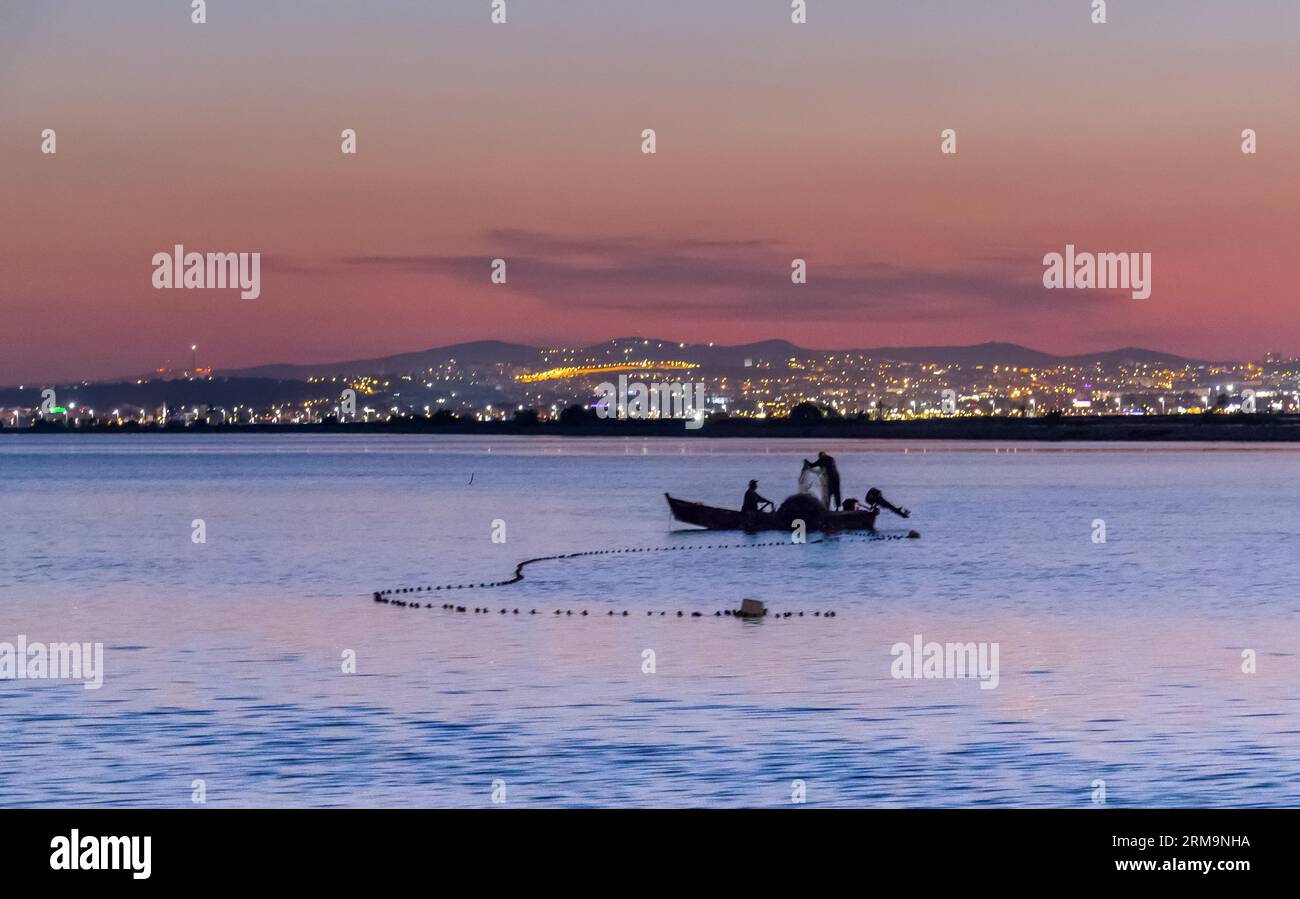 Pescatore in piccola barca al tramonto in Tunisia, Nord Africa Foto Stock