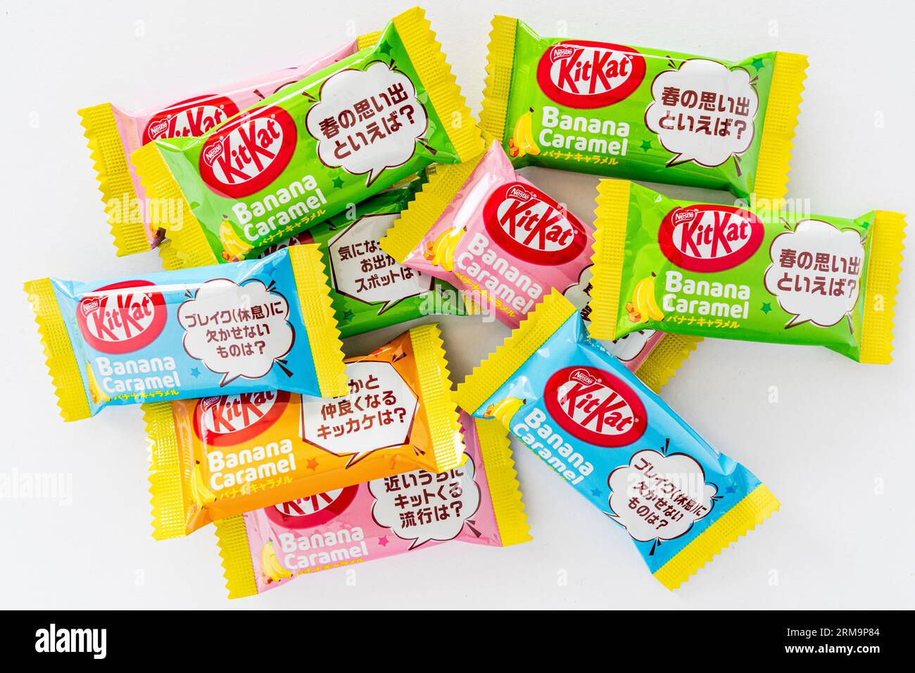 Diversi Kit Kat per mini bar giapponesi con caramello a banana su sfondo bianco semplice. Tutti lo stesso favore ma con involucri di colore diverso. Foto Stock