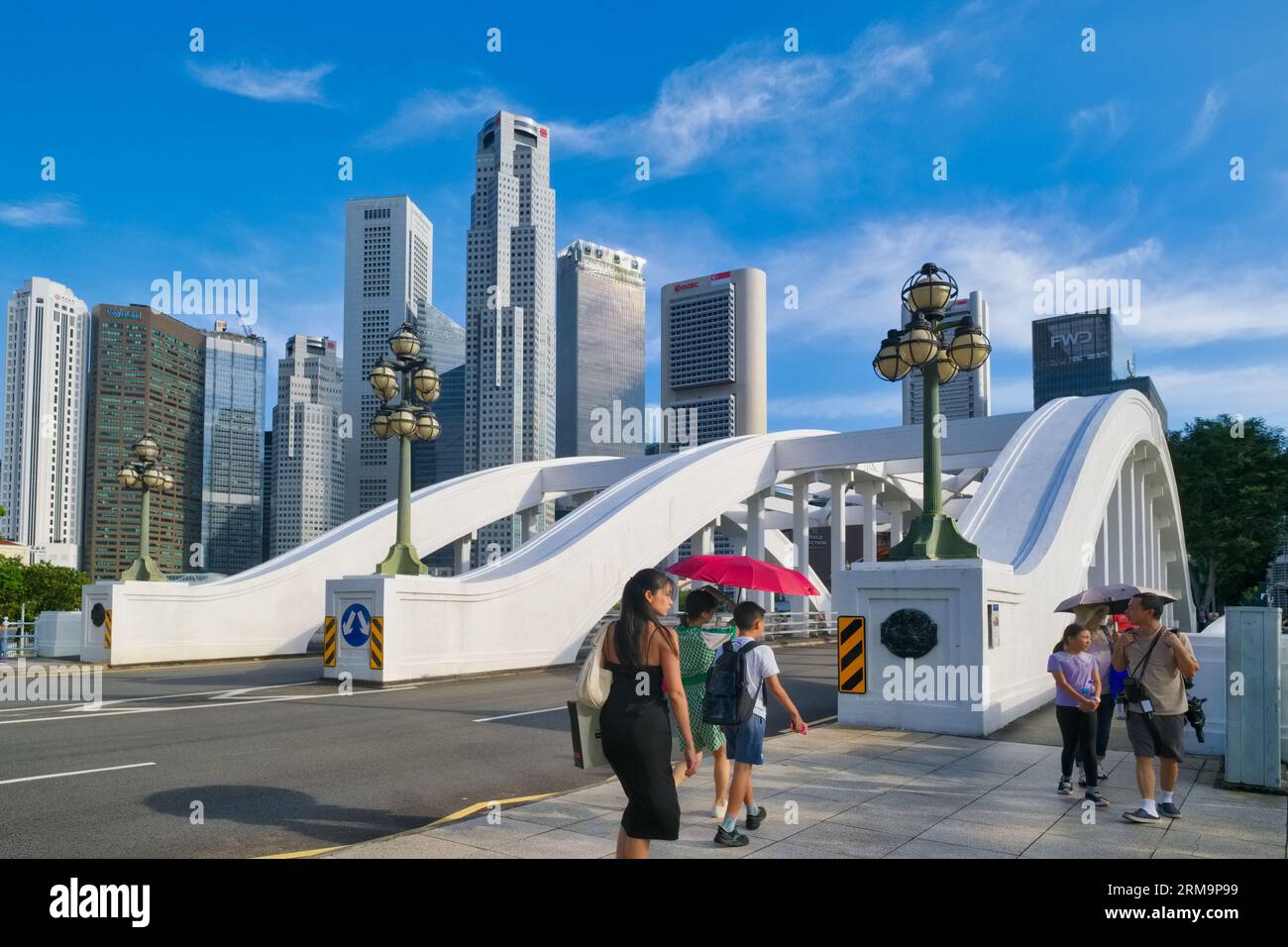 I pedoni attraversano a piedi il Ponte Elgin che attraversa il fiume Singapore, Singapore, gli alti edifici del quartiere degli affari sullo sfondo Foto Stock