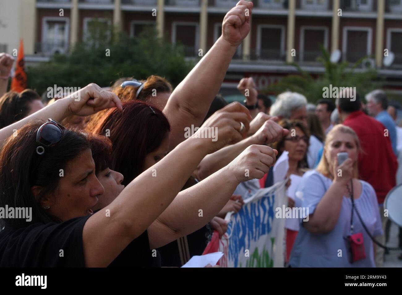 (140605) -- ATENE, 5 giugno 2014 (Xinhua) -- ex personale delle pulizie del ministero delle Finanze, che ha perso il lavoro lo scorso anno, grida slogan fuori da un edificio del ministero delle Finanze nel centro di Atene, Grecia, 5 giugno 2014. Centinaia di persone hanno partecipato a una protesta di solidarietà, chiedendo al governo di rispettare una recente decisione del tribunale di reintegrarli nel loro lavoro. La sentenza del 12 maggio ha rilevato che 397 addetti alle pulizie che hanno presentato la denuncia sono stati erroneamente sospesi dal loro posto di lavoro otto mesi fa, nell'ambito di un programma di riduzione del personale del settore statale. Il governo ha detto che combatterà la sentenza. (Xinhua/Marios Lol Foto Stock