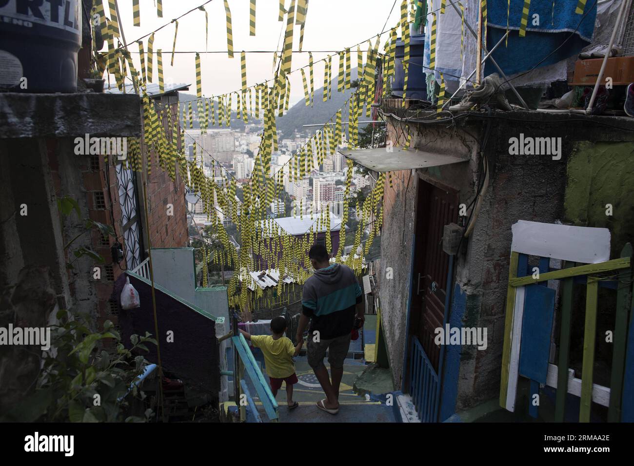 I residenti camminano su una strada a Favela Santa Marta, Rio de Janeiro, Brasile, il 26 giugno 2014. La favela Santa Marta, fondata nel 1920, è una delle favelas più antiche di Rio de Janeiro. Divenne famoso nel 1996, quando il cantante pop americano Michael Jackson registrò un videoclip a Santa Marta per la sua canzone They Don t Care About Us. Dopo che la Pacifying Police Unit (UPP) prese il controllo di Santa Marta nel 2008, divenne un modello per tutte le favelas di Rio de Janeiro e anche un punto panoramico. (Xinhua/Guillermo Arias) (SP)BRASILE-RIO DE JANEIRO-FAVELA SANTA Marta PUBLICATIONxNOTxINxCHN i residenti camminano SU una strada a Fave Foto Stock