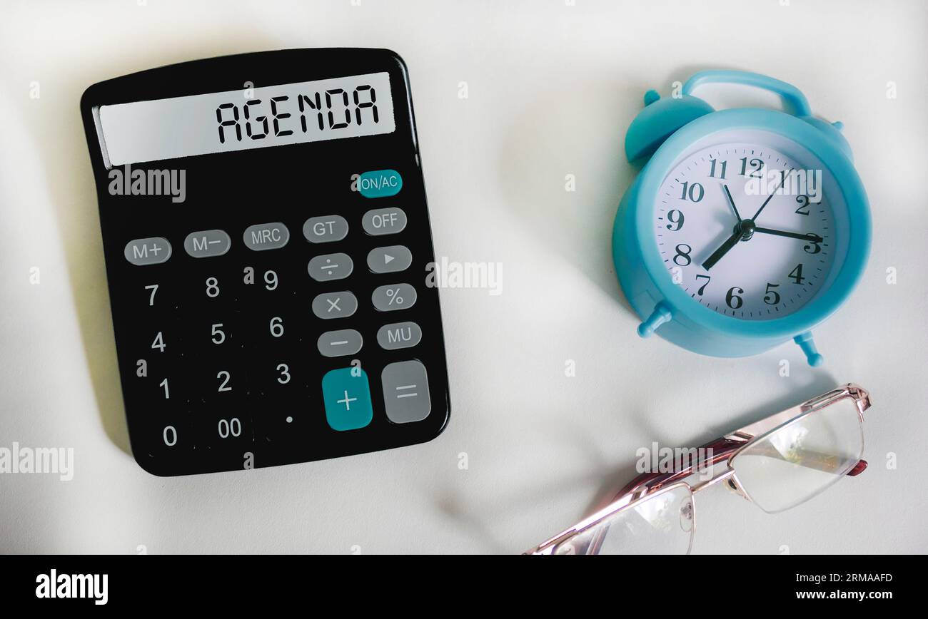 Simbolo del programma. Calcolatrice con parola Agenda Concept su sfondo bianco con orologio e occhiali. Foto Stock