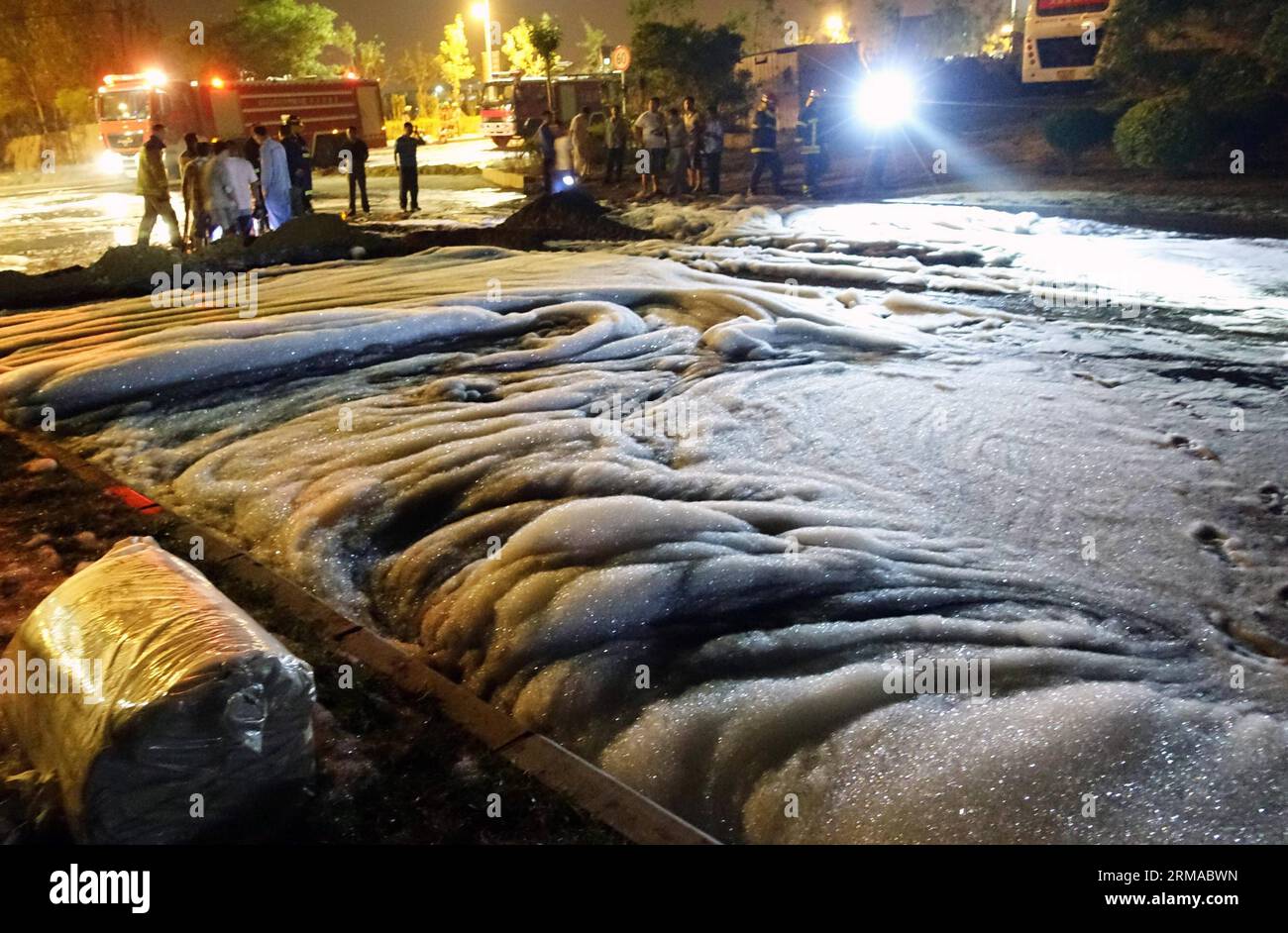 (140701) -- DALIAN, 1° luglio 2014 (Xinhua) -- le schiume utilizzate per diluire il petrolio greggio si diffondono su tutta la strada dopo una fuoriuscita di petrolio greggio da un oleodotto di PetroChina, il più grande produttore di petrolio e gas del paese, hanno causato un enorme incendio a Dalian, una città costiera nella provincia di Liaoning della Cina nord-orientale, il 1° luglio 2014. L'oleodotto nei pressi dell'Università di Dalian nel nuovo distretto di Jinzhou è stato danneggiato e il petrolio è fuoriuscito a causa delle operazioni di perforazione di una società di ingegneria edile locale lunedì sera. La fuoriuscita è volata nella rete di gasdotti urbani e un incendio è scoppiato all'uscita dei gasdotti urbani. Residente Foto Stock