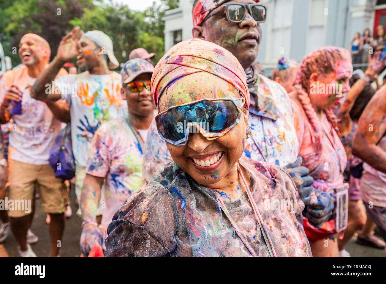 Londra, Regno Unito. 27 agosto 2023. Molti sono rivestiti di polvere colorata e olio dalla cerimonia di apertura di Jouvert al mattino presto - ballando dietro camion con grandi impianti audio prima della sfilata - la domenica del Carnevale di Notting Hill, tradizionalmente giorno dei bambini. L'evento annuale per le strade del Royal Borough di Kensington e Chelsea, durante il fine settimana festivo di agosto. È guidato da membri della comunità britannica delle Indie occidentali e attrae circa un milione di persone all'anno, rendendolo uno dei più grandi festival di strada del mondo. Crediti: Guy Bell/Alamy Live News Foto Stock