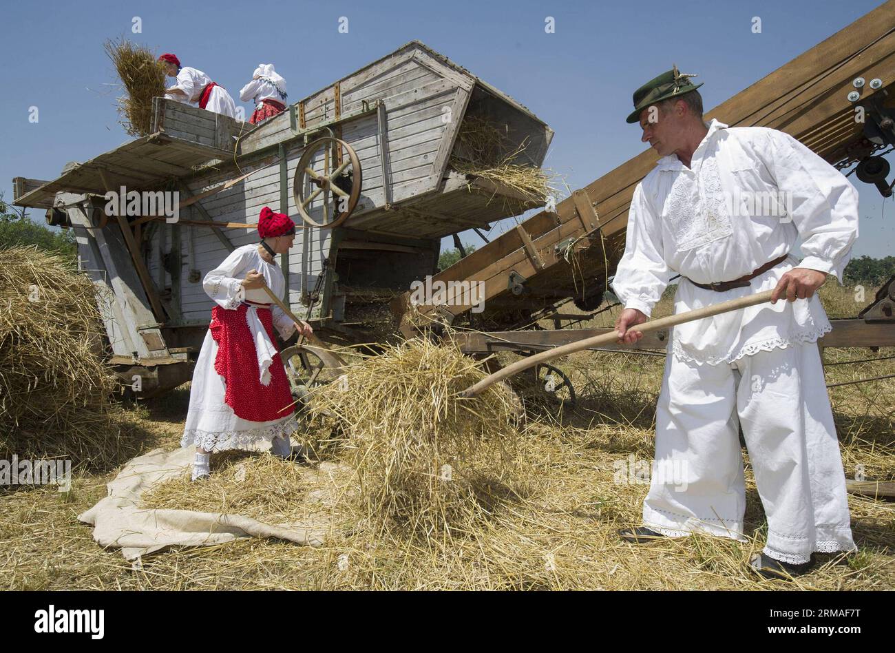 ZAGABRIA, 5 luglio 2014 (Xinhua) -- persone che indossano costumi tradizionali tremolini durante il 12 ° evento raccolto e trebbiatura nel passato a Zupanja, Croazia, 5 luglio 2014. Celebrando il duro lavoro e la bellezza della tradizione del raccolto del popolo slavo, gli agricoltori locali e i turisti della Bosnia-Erzegovina e della Serbia hanno vissuto la vita rurale nella regione storica orientale della Croazia, la Slavonia. (Xinhua/Miso Lisanin) (dzl) CROAZIA-ZUPANJA-HARVEST-TRADITION PUBLICATIONxNOTxINxCHN Zagreb 5 luglio 2014 celebrità di XINHUA che indossano costumi tradizionali trebbiati durante la dodicesima vendemmia e tre Foto Stock