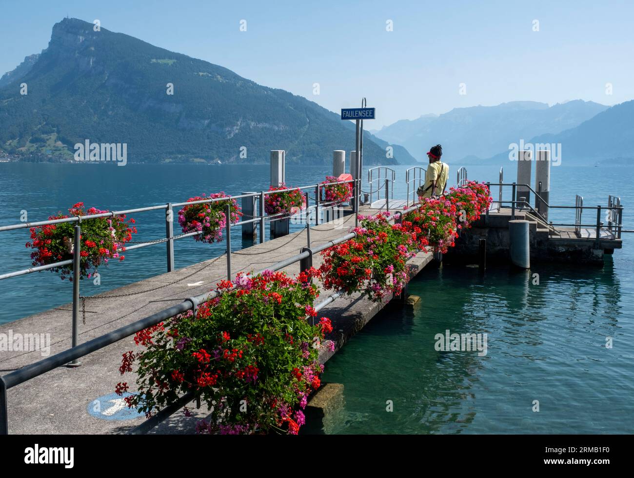 Un passeggero aspetta sul molo di Faulensee, sul lago di Thun, sul cantone di Berna, in Svizzera. Foto Stock