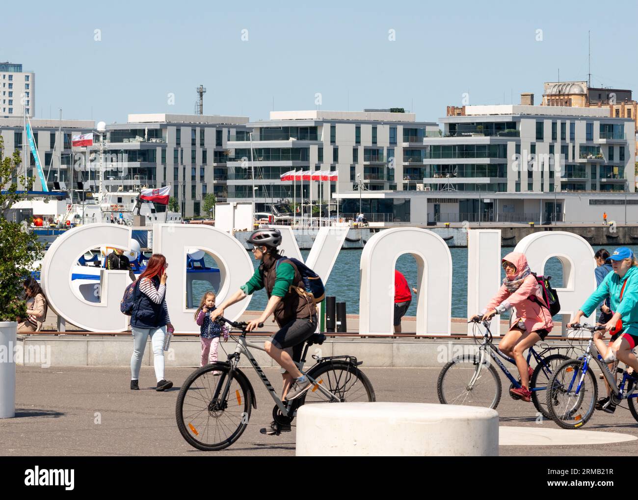 I ciclisti al cartello di Gdynia e luogo turistico simbolo del porto cittadino di Gdynia, Polonia Foto Stock