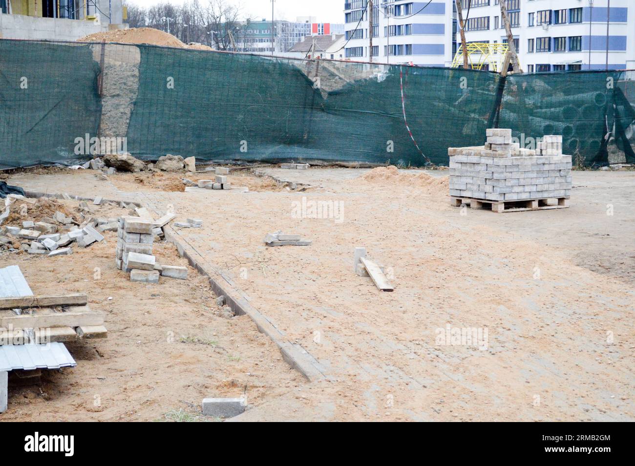 Un disordine in un cantiere con materiali da costruzione sparsi e rifiuti con sporco, scarse precauzioni di sicurezza, condizioni igieniche e ambientali Foto Stock