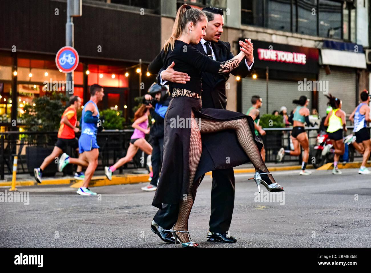 Buenos Aires, Argentina. 27 agosto 2023. 27 agosto 2023 - Buenos Aires, Argentina - Una coppia balla Tango davanti agli atleti. Più di 20.000 partecipanti e atleti di alto livello si sono riuniti a Buenos Aires per partecipare a un evento speciale pieno di entusiasmo e nell'ambito di un'atmosfera festosa.con l'energia di 23.000 corridori e la prima luce di domenica nelle strade di Buenos Aires, si è svolto l'evento internazionale di atletica ''21k della città di Buenos Aires'', uno dei più importanti della storia per la sua massiccia massa e, nel caso della zona d'élite, per la q Foto Stock