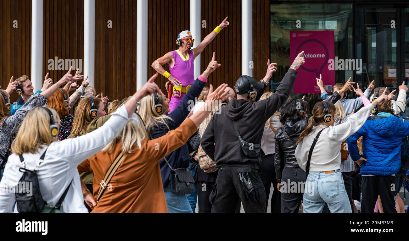 Edimburgo, Scozia, Regno Unito, 27 agosto 2023. Silent disco: Un gruppo numeroso ama la musica attraverso le cuffie mentre viene condotto in giro per la città ballando sulla musica pop solo che possono ascoltare. Crediti: Sally Anderson/Alamy Live News Foto Stock