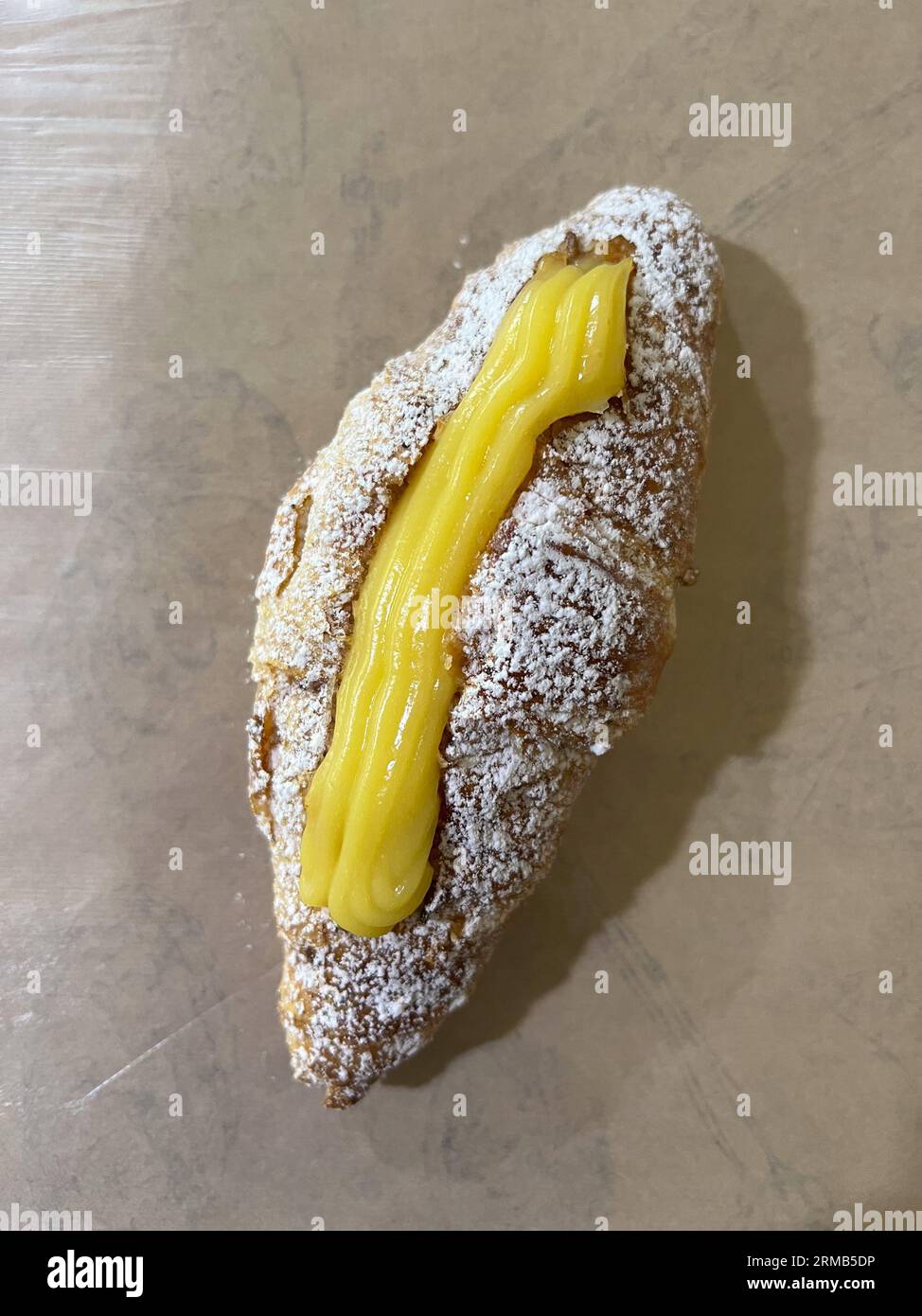 Croissant con ripieno di panna su carta Foto Stock