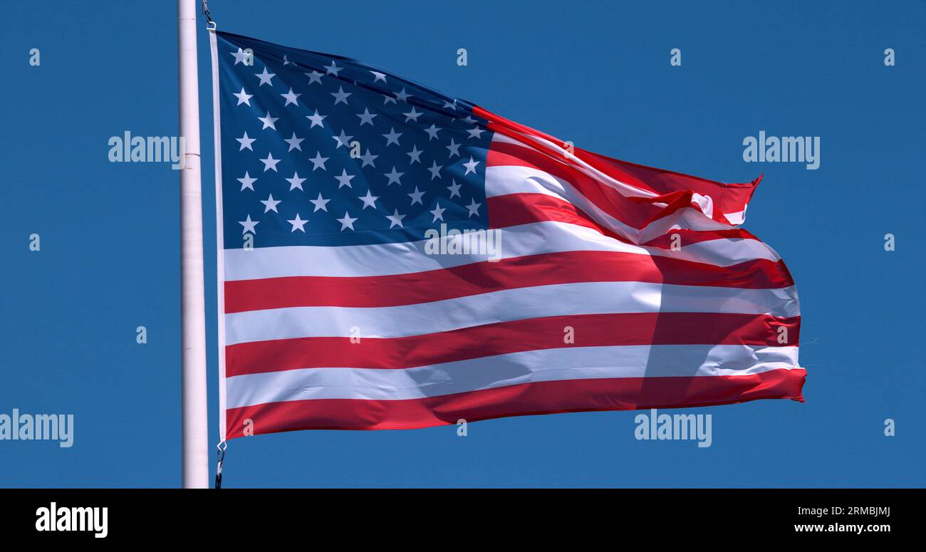 Bandiera americana che sventola nel vento contro il cielo blu Foto Stock