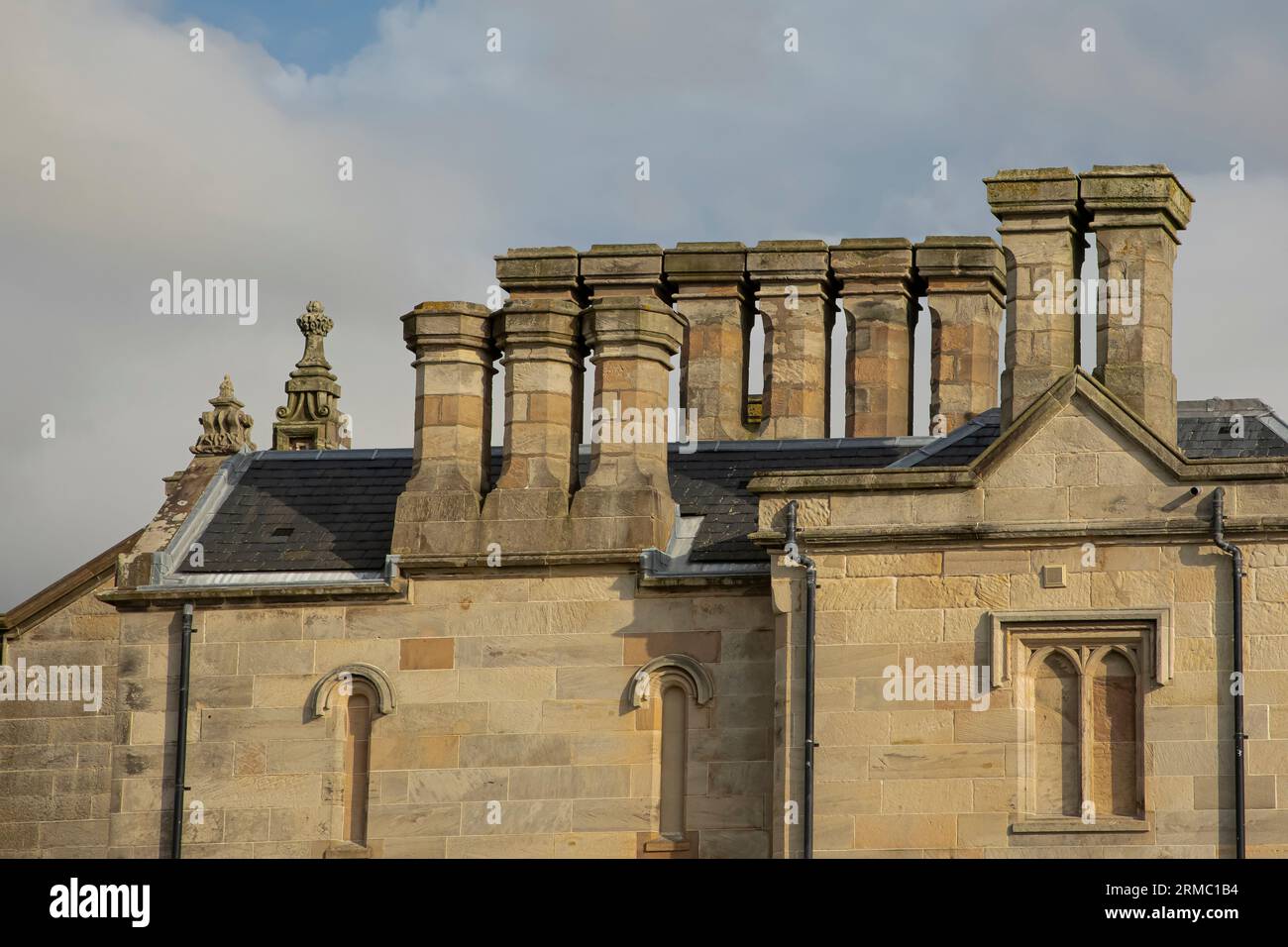 Set unico di multiplechimney di un edificio in pietra di colore pallido Foto Stock