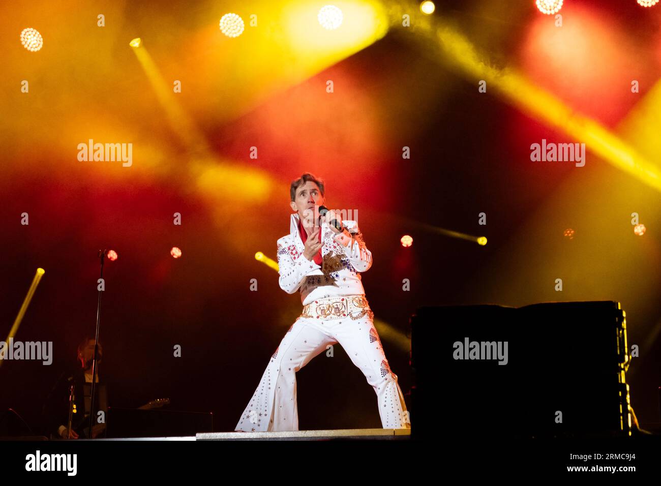 Rob Brydon sul palco principale del Carfest 2023, esibendosi come Terry Jenkins, un imitatore di Elvis con il Supergruppo. Foto Stock