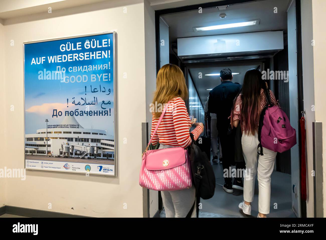 Poster multilingue che dice addio! In 7 lingue prima dell'uscita del corridoio d'ingresso per l'aereo nell'aeroporto di Antalya in Turchia. Passeggeri in partenza dal terminal Foto Stock