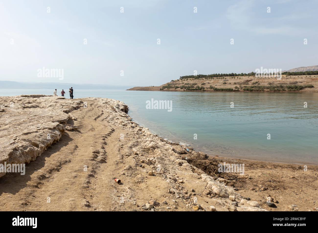 I turisti di Salty Rocks si trovano sulla costa del Mar morto in Giordania Foto Stock