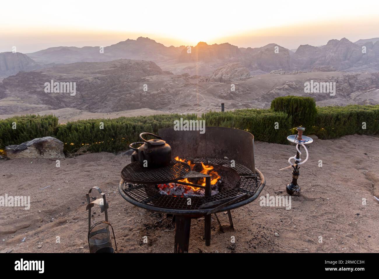 Ha creato un punto di fuoco con un bollitore acceso e un narghilè accanto ad esso nelle montagne Petra in Giordania Foto Stock