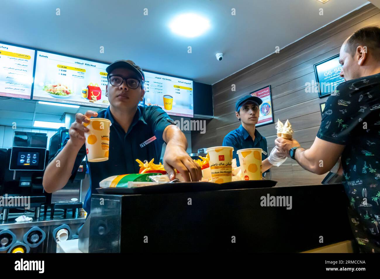 Impiegato di sesso maschile che consegna l'ordine McDonalds al ristorante McDonalds Aqaba Jordan Foto Stock