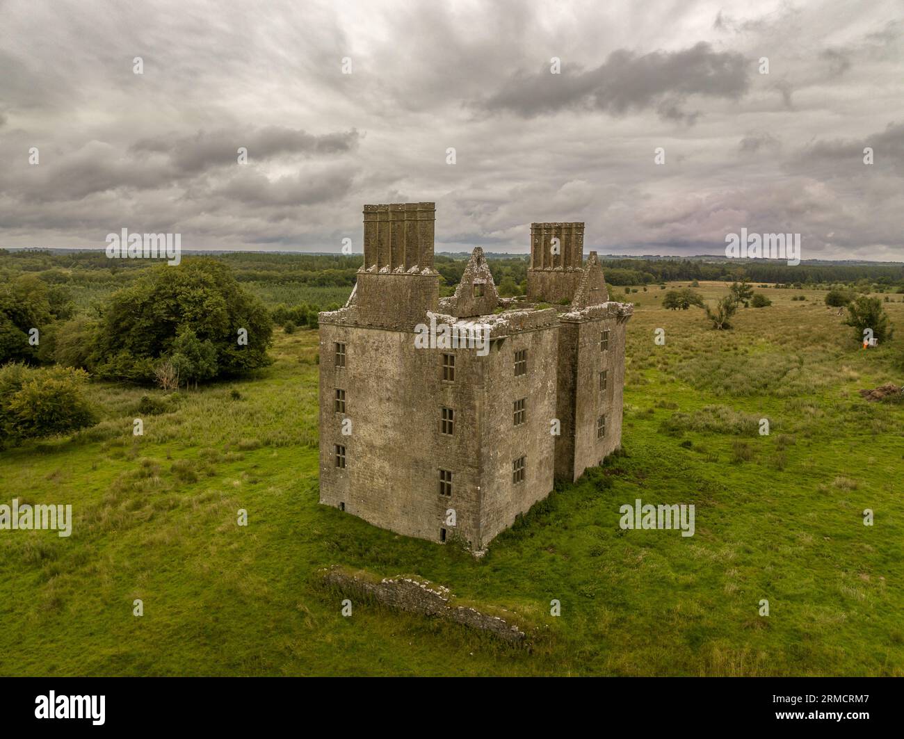 Vista aerea del castello di Glinsk, casa medievale fortificata in Irlanda con struttura simmetrica, cinque lunghi camini alti su ciascun lato, County Calway Foto Stock