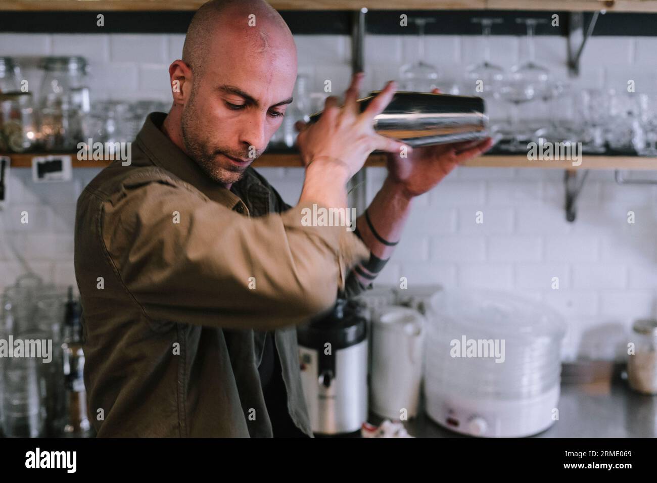 Il giovane barman prepara un cocktail alcolico al bar Foto Stock