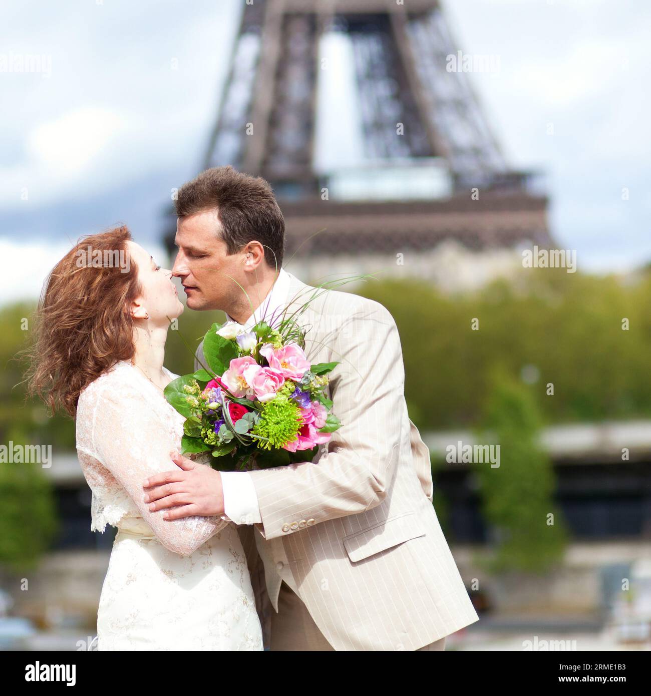 La coppia sposata si baciava vicino alla Torre Eiffel Foto Stock