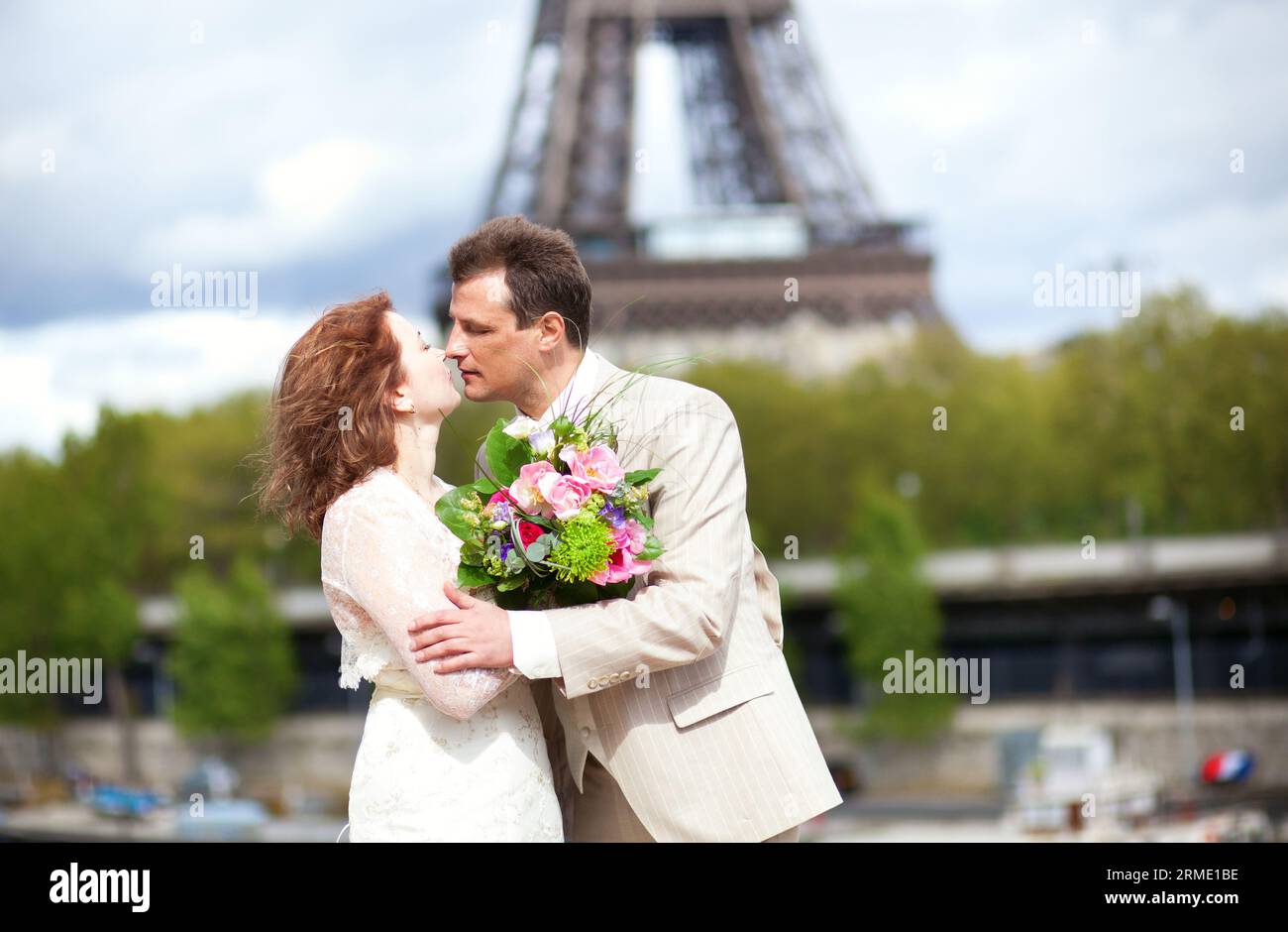 La coppia sposata si baciava vicino alla Torre Eiffel Foto Stock