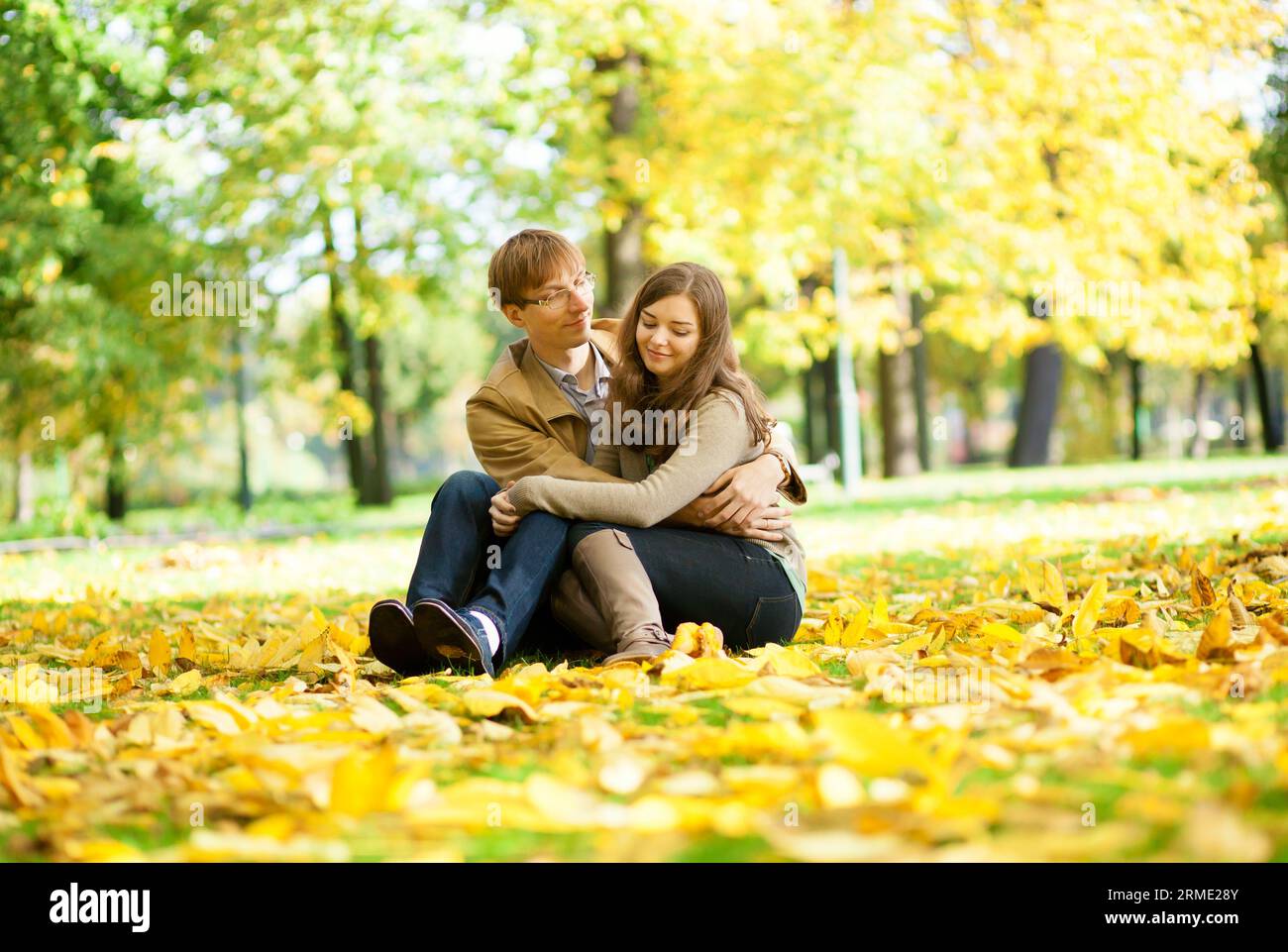 Uscire con una coppia in foglie gialle in un giorno d'autunno Foto Stock