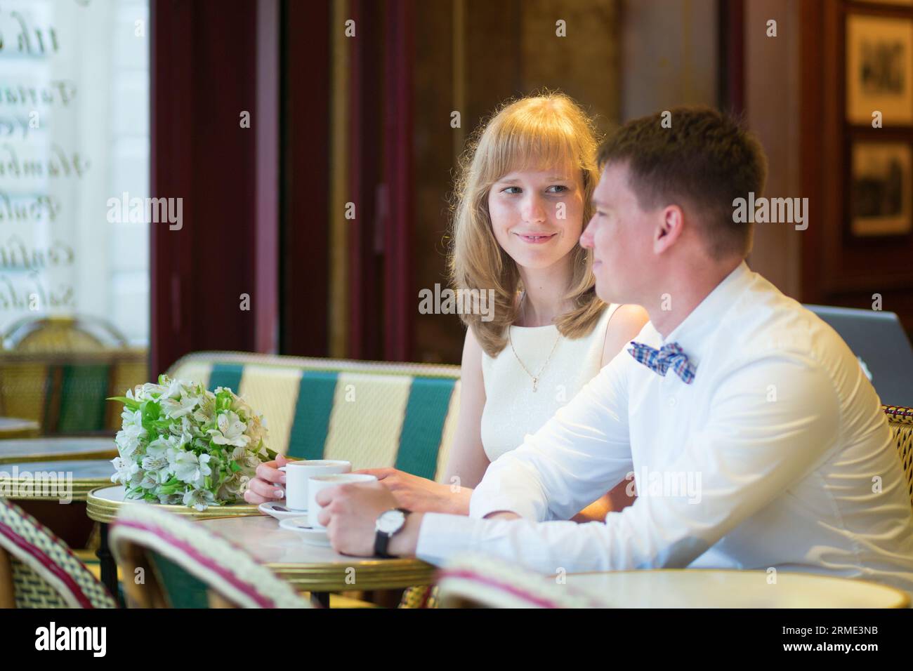 Bella coppia appena sposata che beve un caffè in un caffè parigino Foto Stock