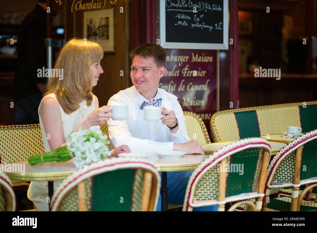 Bella coppia appena sposata che beve un caffè in un caffè parigino Foto Stock