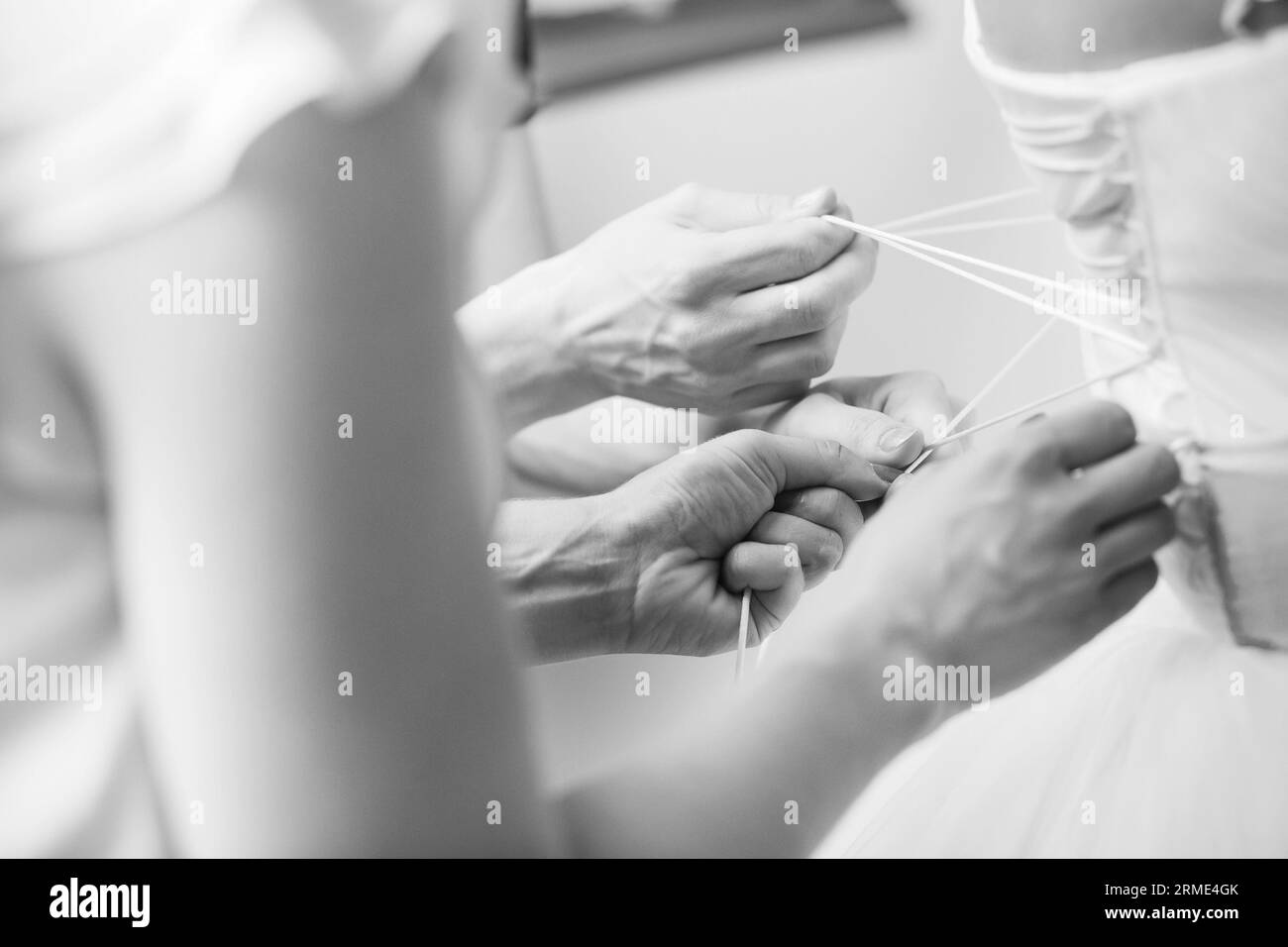 Damigelle che aiutano la sposa a indossare il suo vestito da sposa Foto Stock