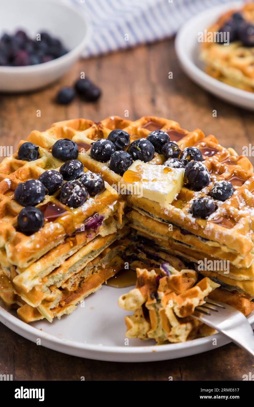 Pila di waffle belgi ai mirtilli tagliati con la forchetta Foto Stock