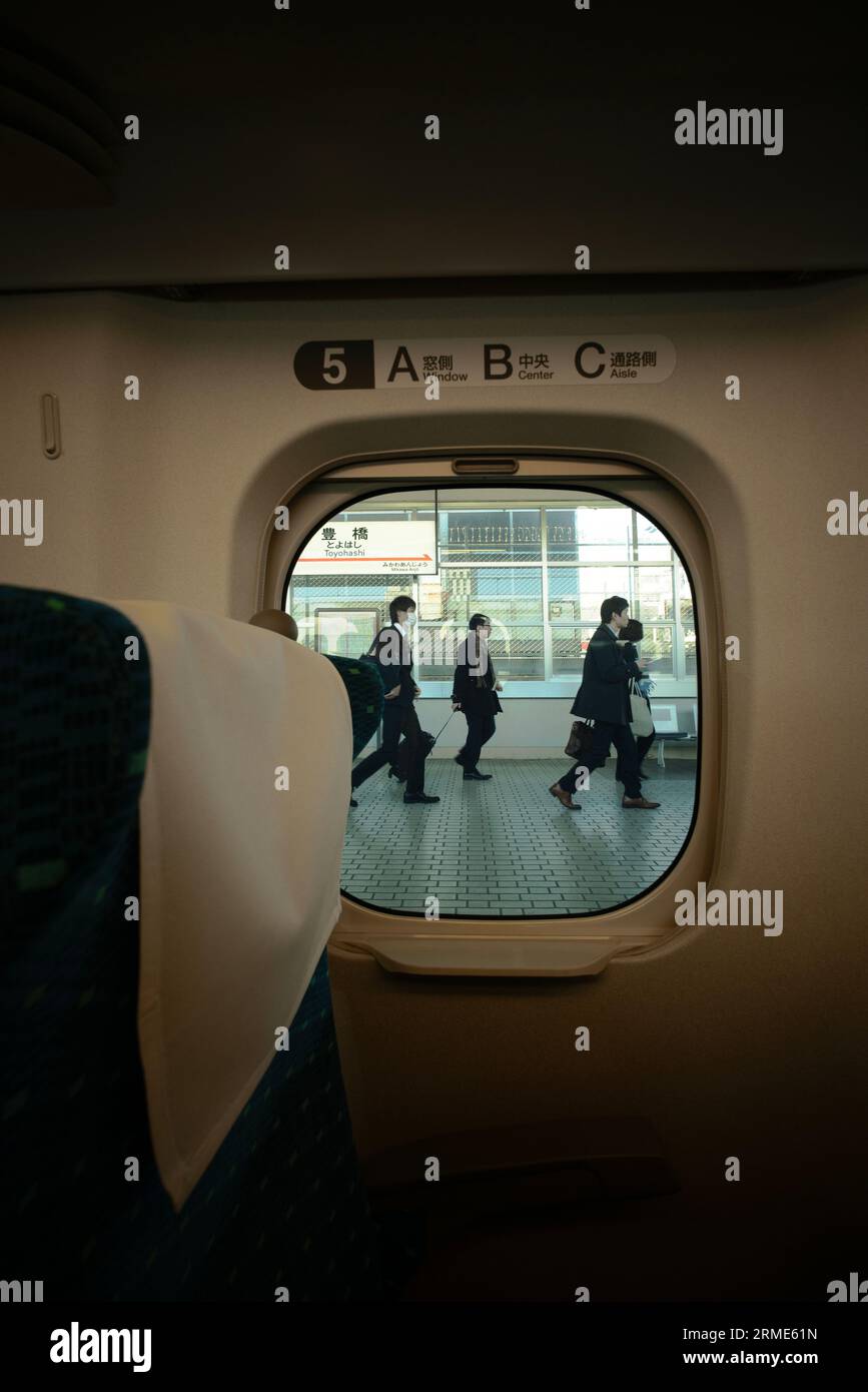 Guardando fuori dall'interno del treno i pendolari a piedi Foto Stock